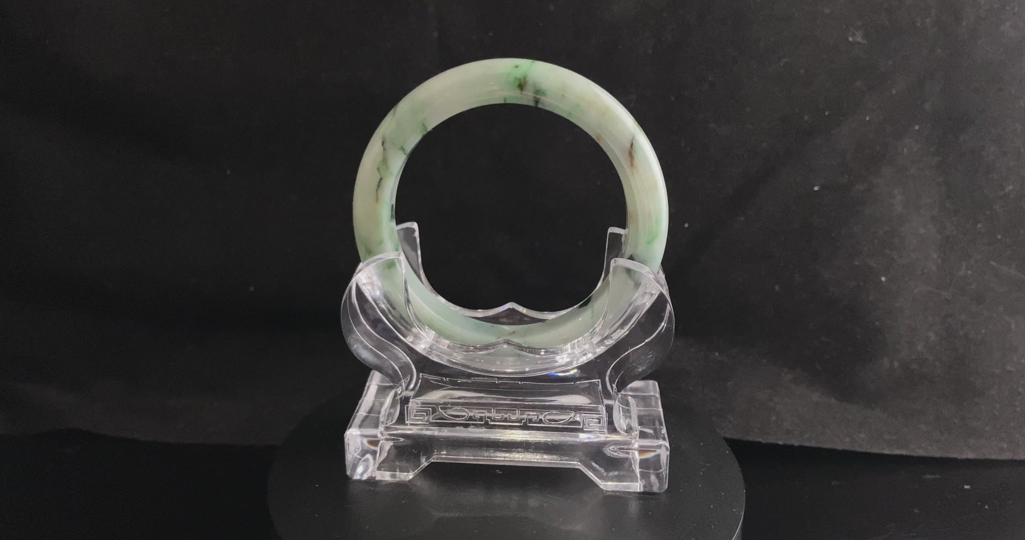 A white base with multi-colored inclusions jadeite bangle.
