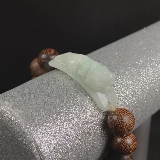 A white green Pixiu’s blessing jadeite agarwood bracelet.