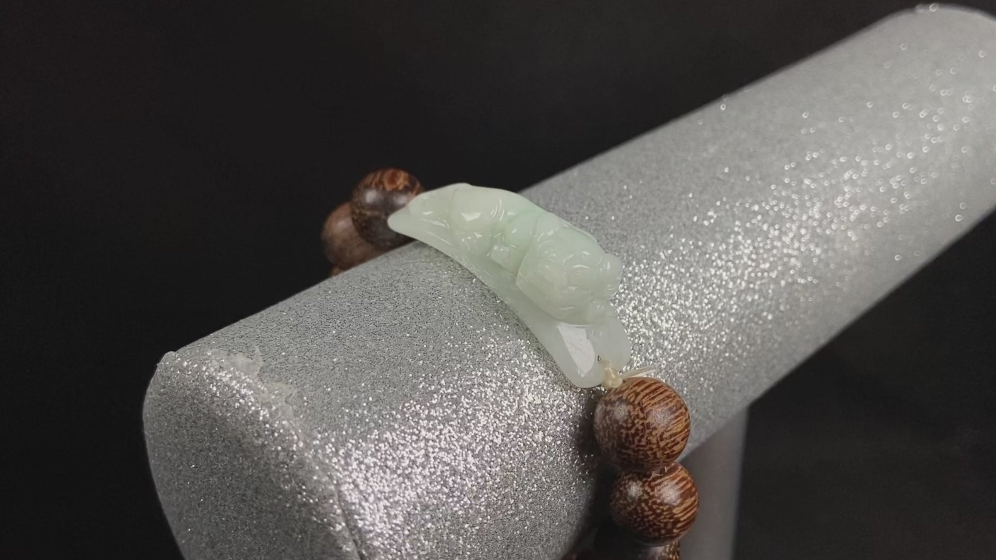 A white green Pixiu’s blessing jadeite agarwood bracelet.