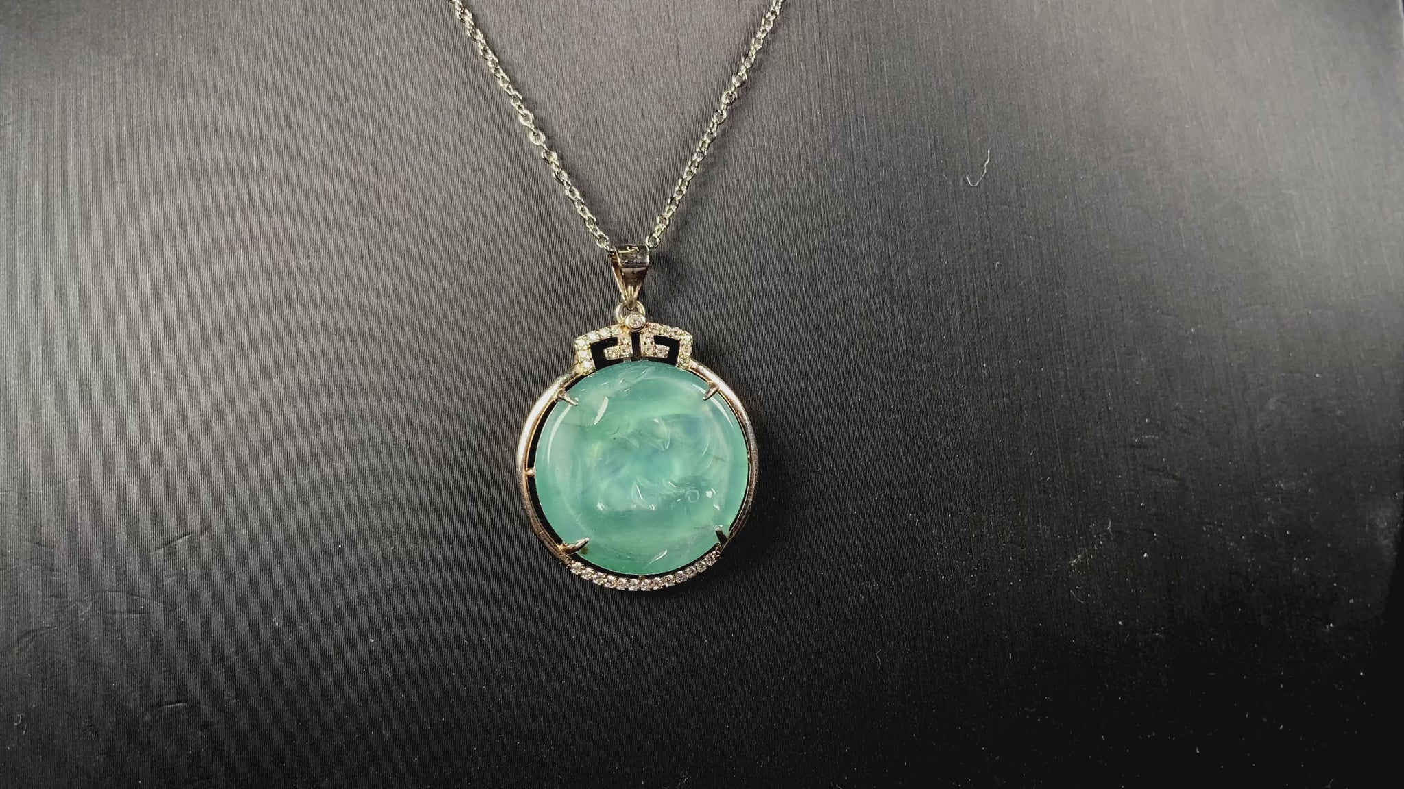 A jelly green twin fish jadeite pendant.