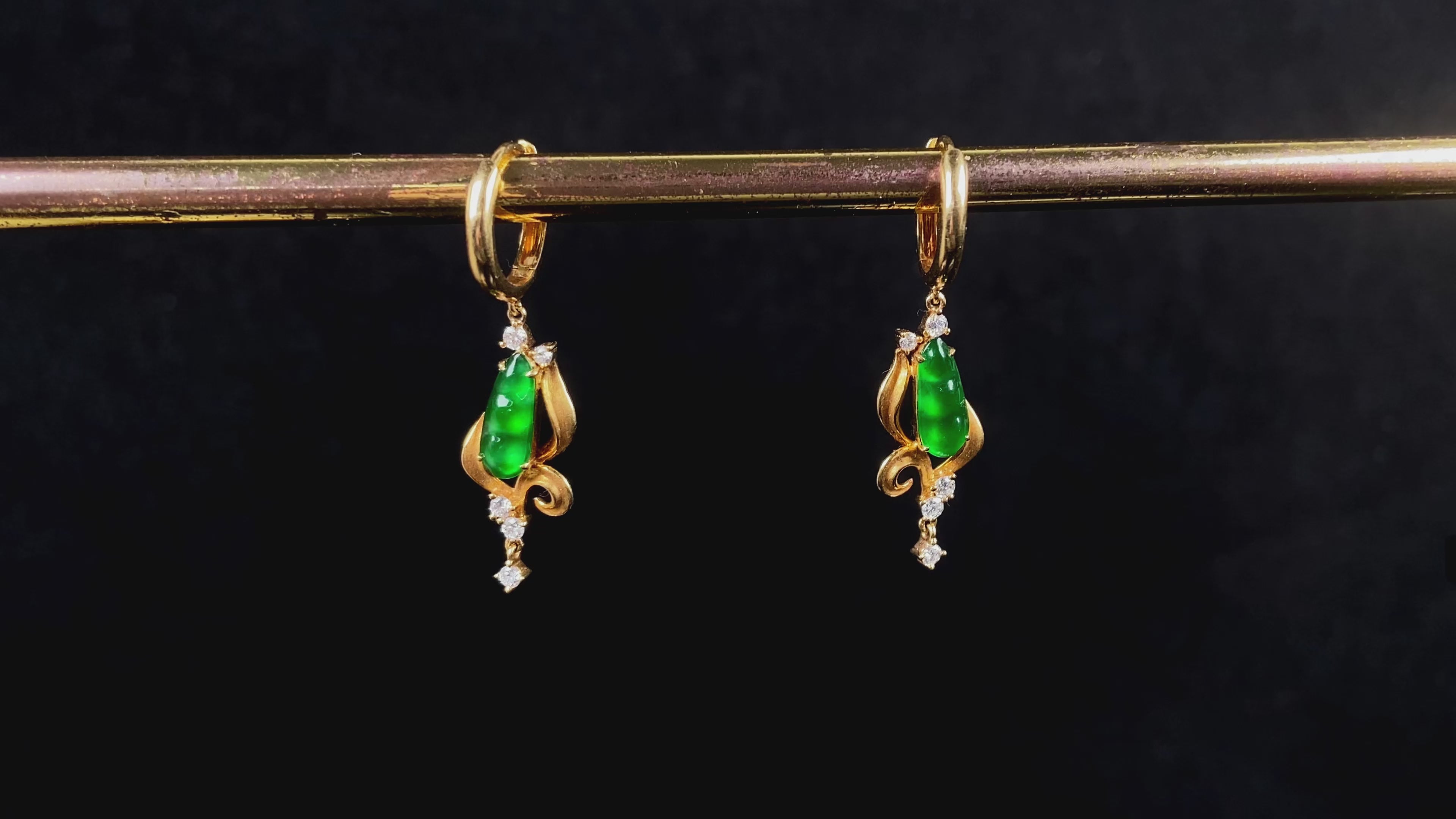 Load video: A pair of vivid green snap pea jadeite earrings.