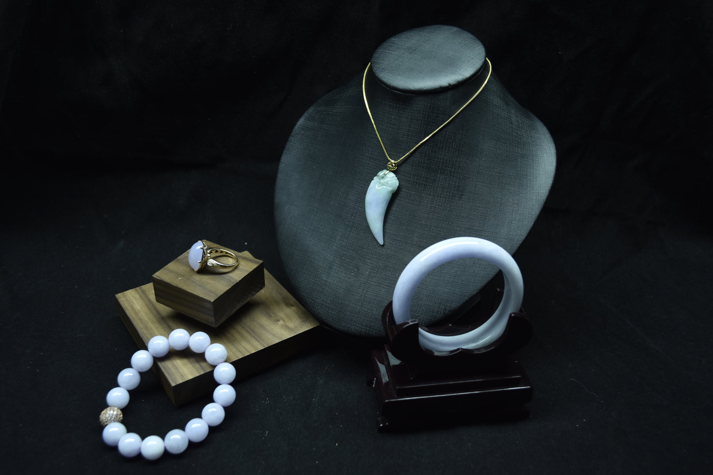 Jewelry including a necklace, ring, and bracelet on a dark background