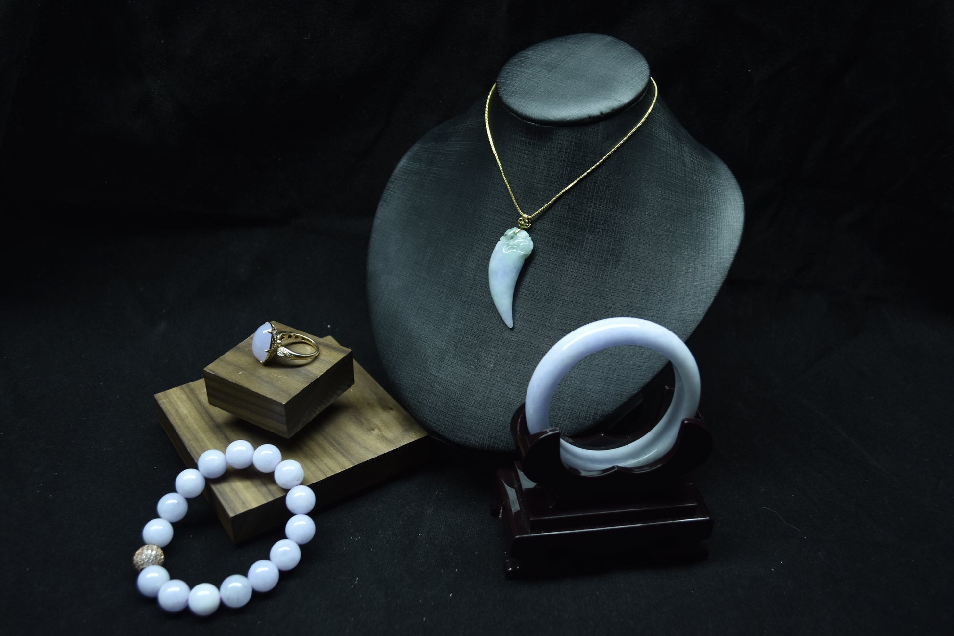 Jewelry including a necklace, ring, and bracelet on a dark background