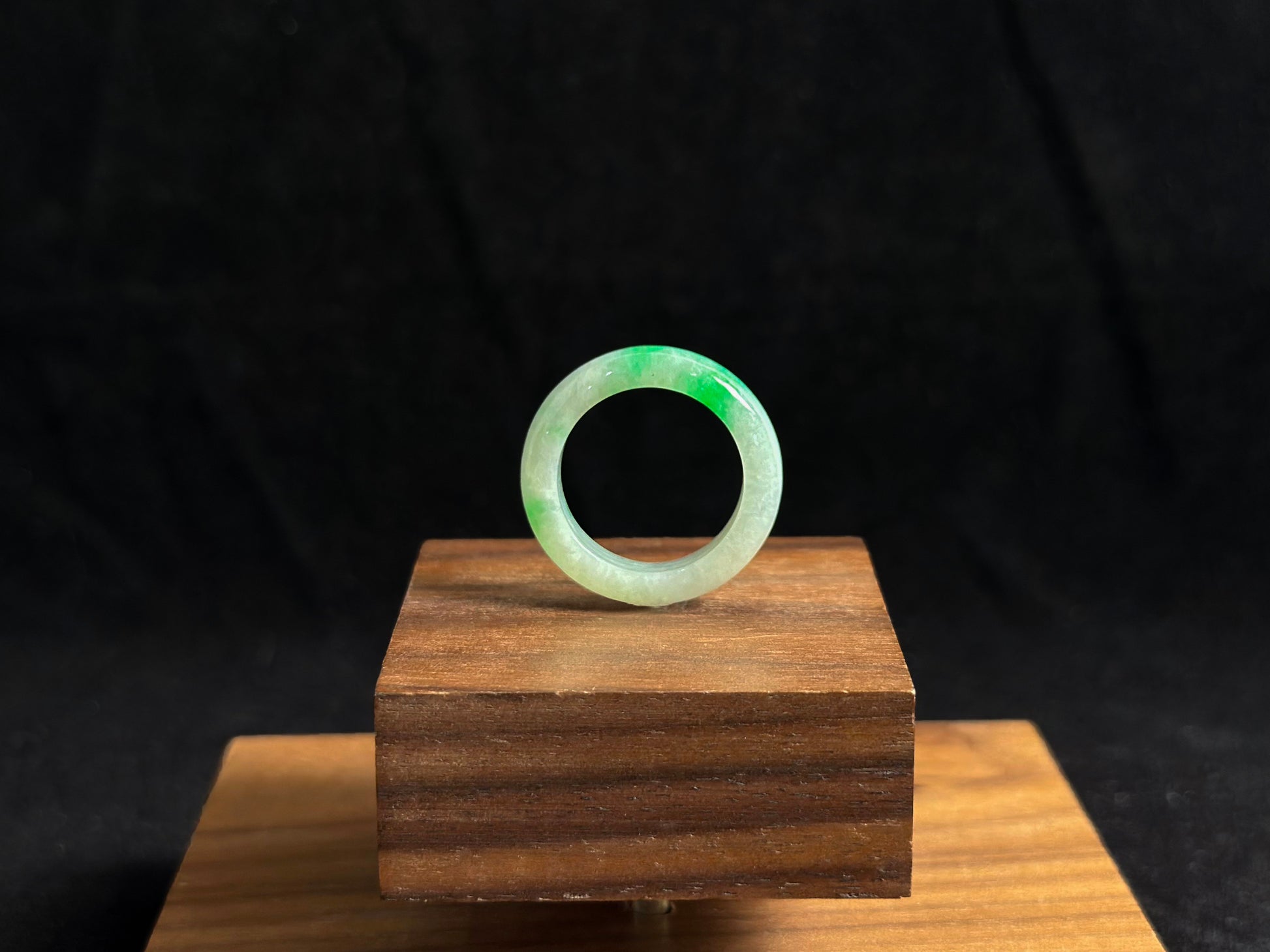 This elegant jade ring features a translucent white base adorned with naturally floating green inclusions.