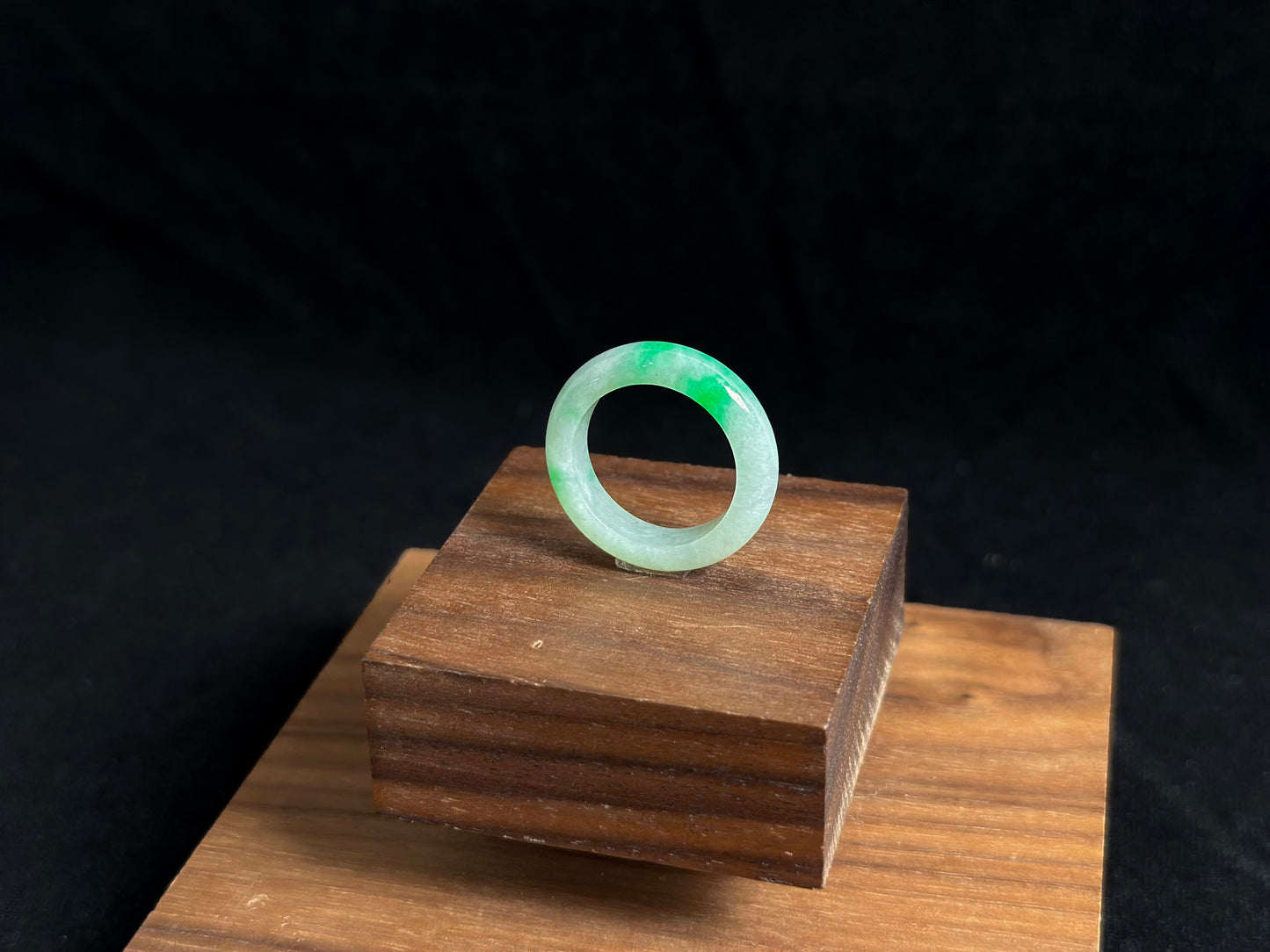 This elegant jade ring features a translucent white base adorned with naturally floating green inclusions.