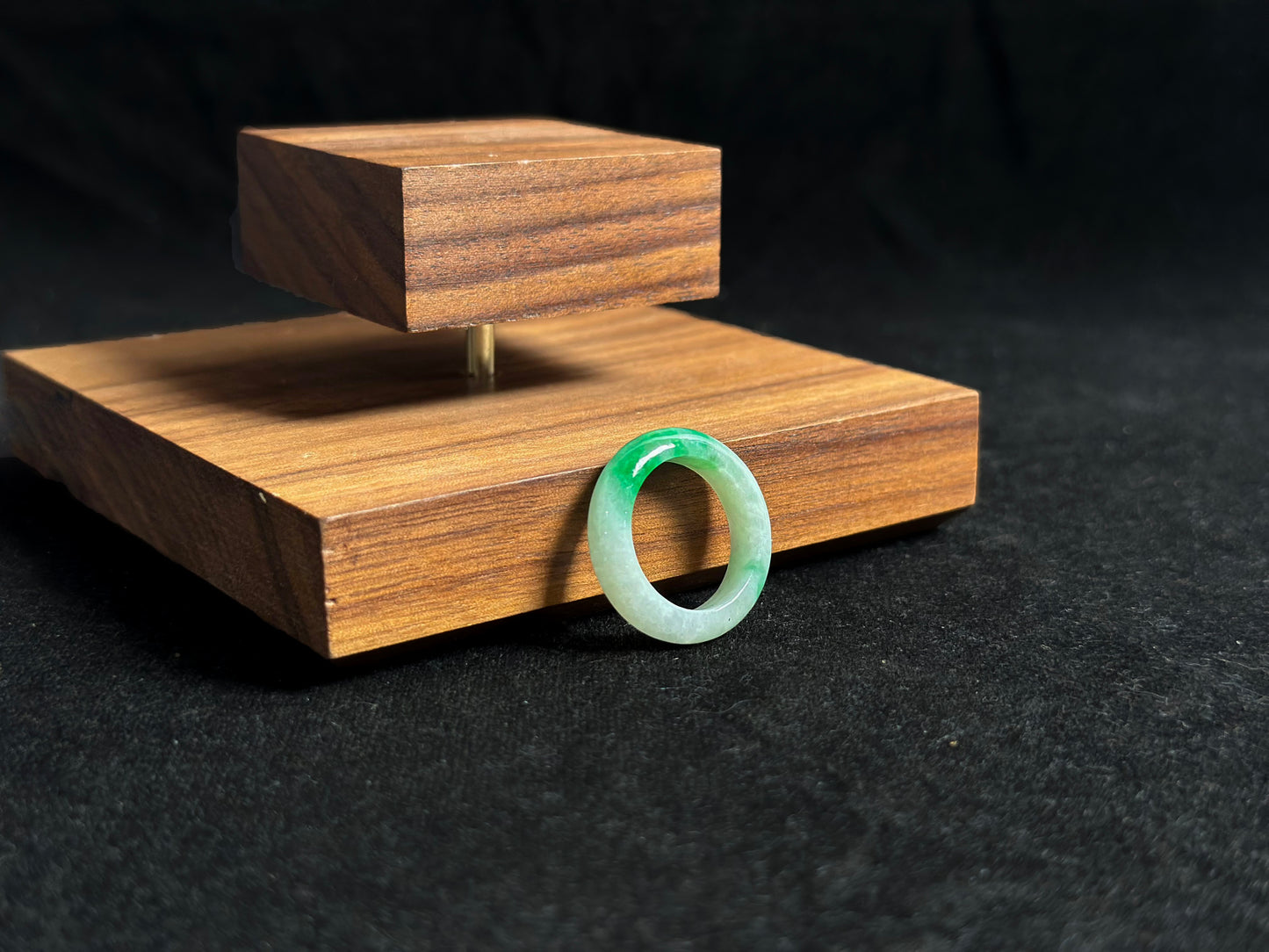 This elegant jade ring features a translucent white base adorned with naturally floating green inclusions.