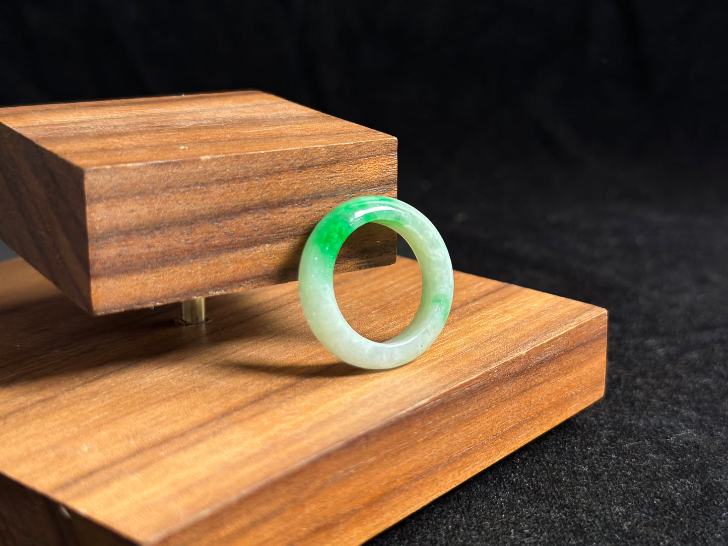 This elegant jade ring features a translucent white base adorned with naturally floating green inclusions.