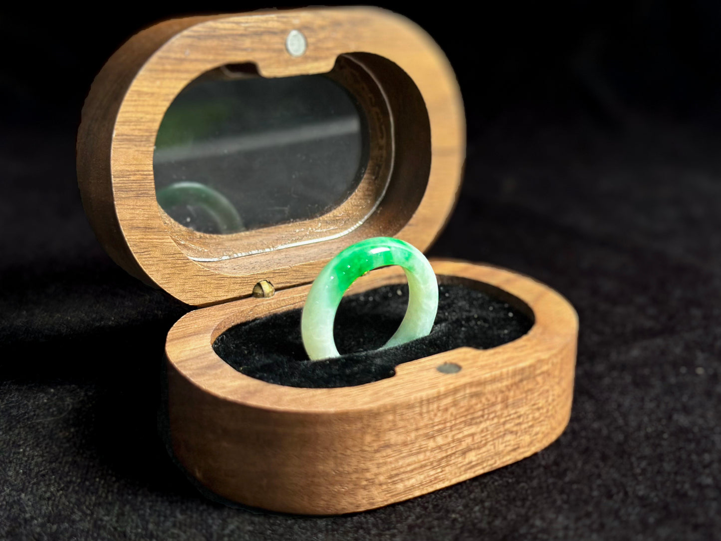 This elegant jade ring features a translucent white base adorned with naturally floating green inclusions.