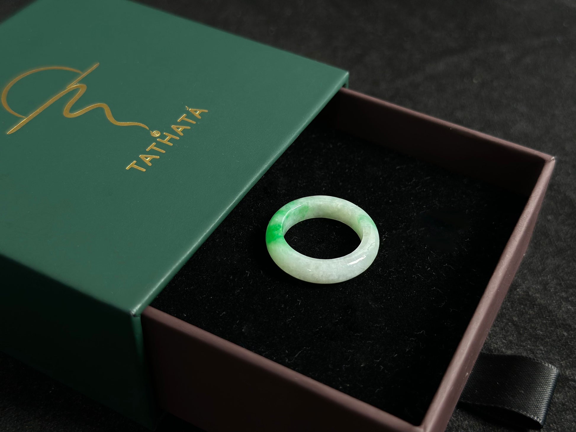 This elegant jade ring features a translucent white base adorned with naturally floating green inclusions.