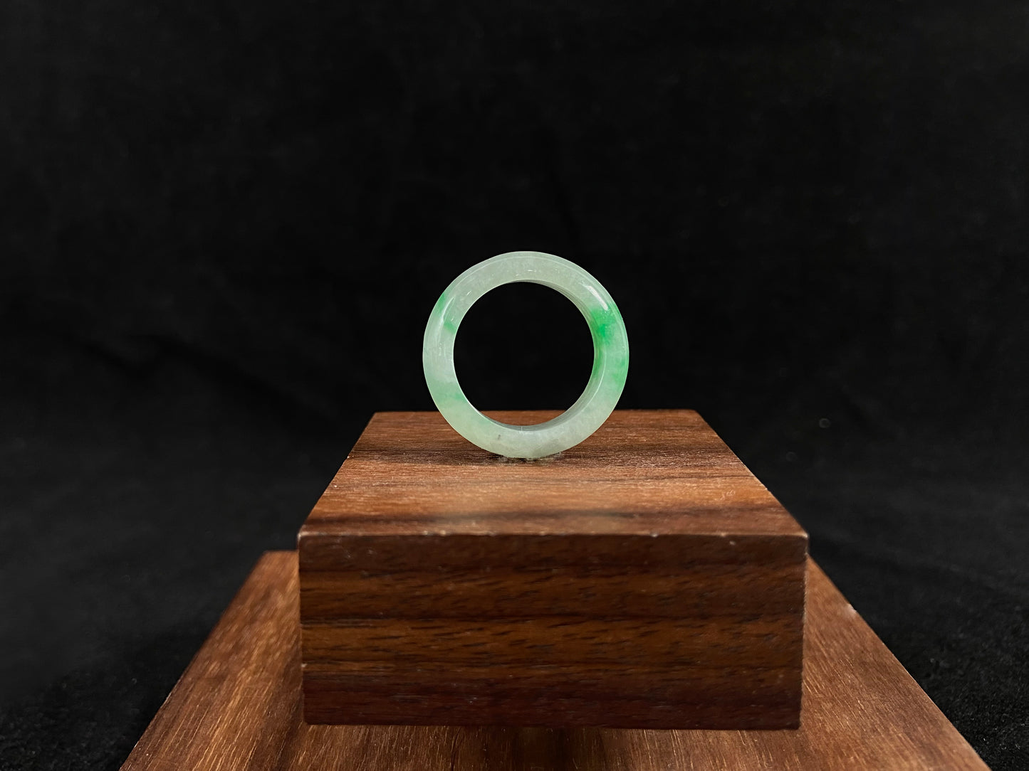 An icy white jadeite ring with natural green accents.
