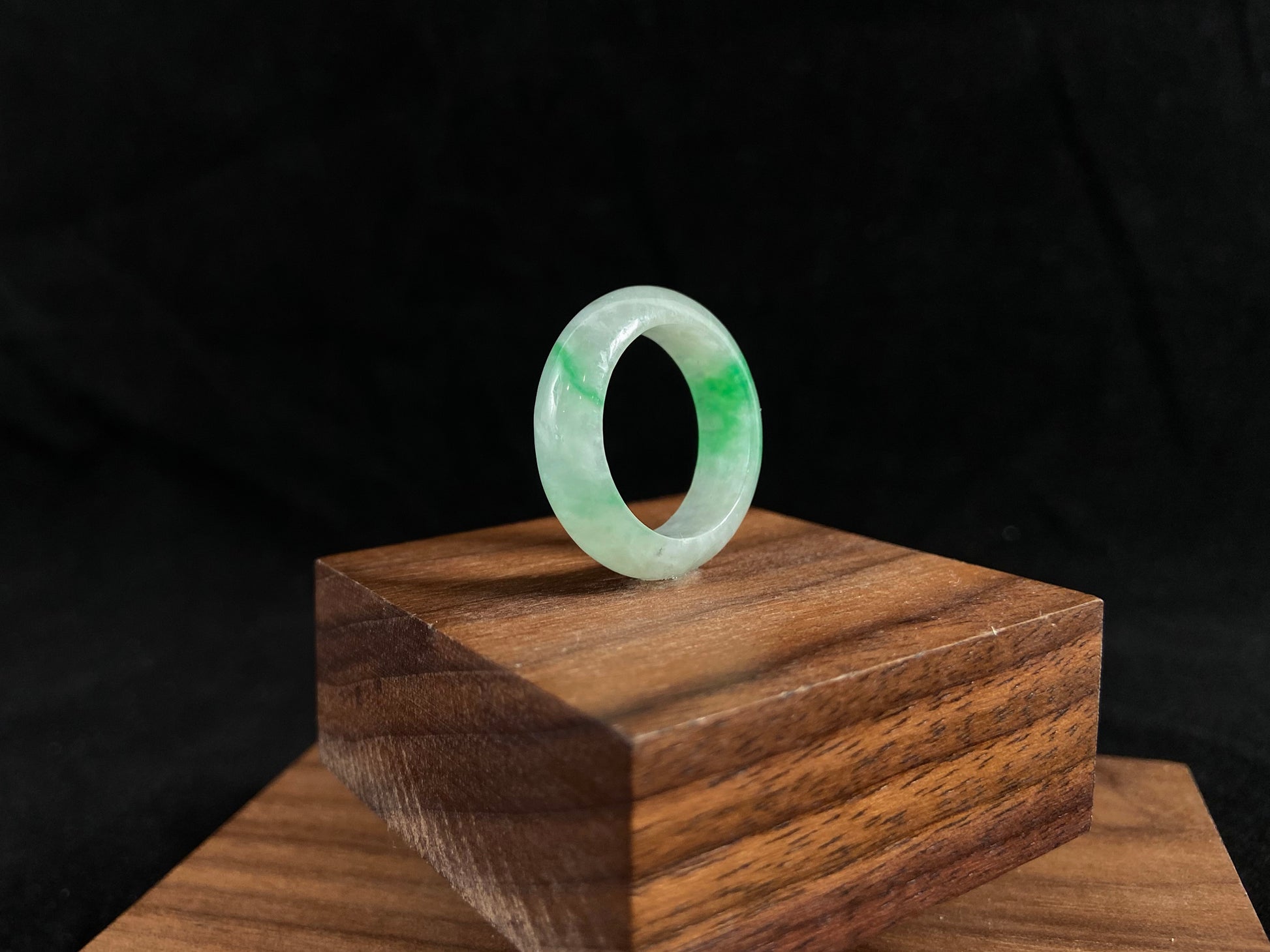 An icy white jadeite ring with natural green accents.