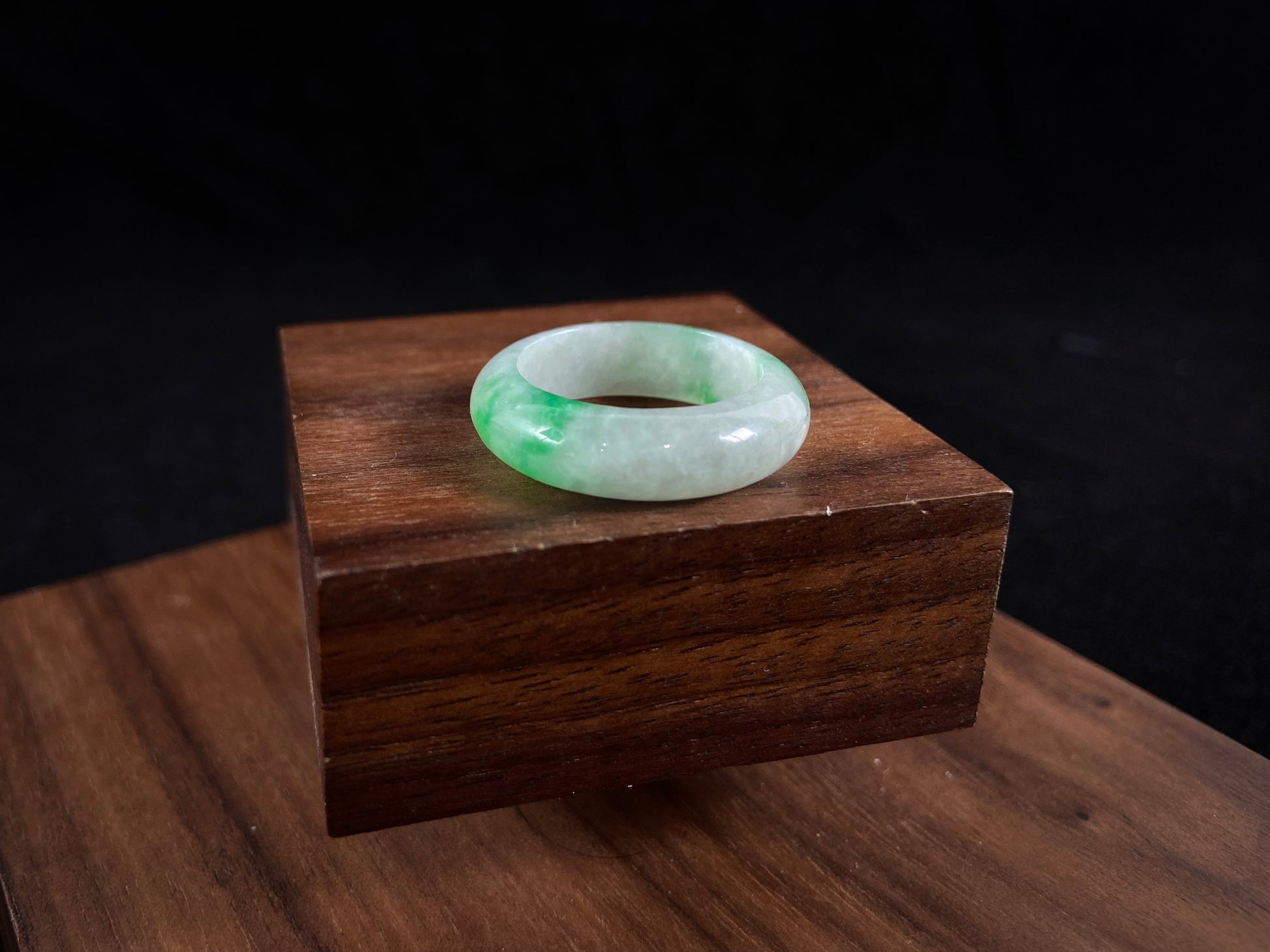 An icy white jadeite ring with natural green accents.