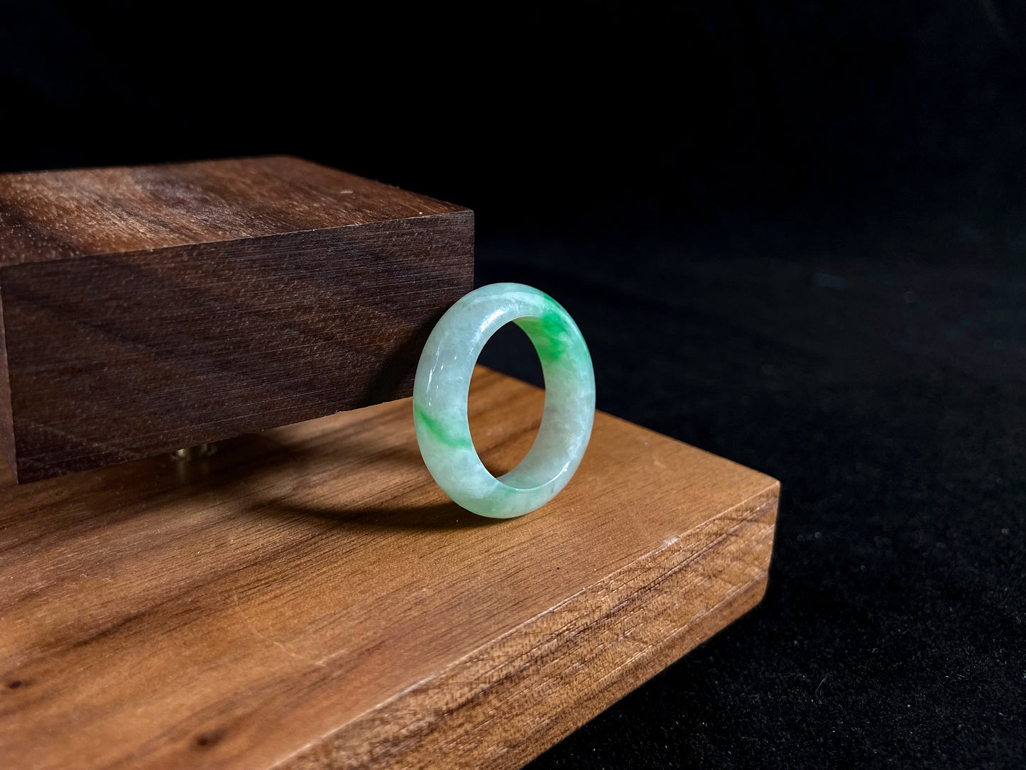 An icy white jadeite ring with natural green accents.