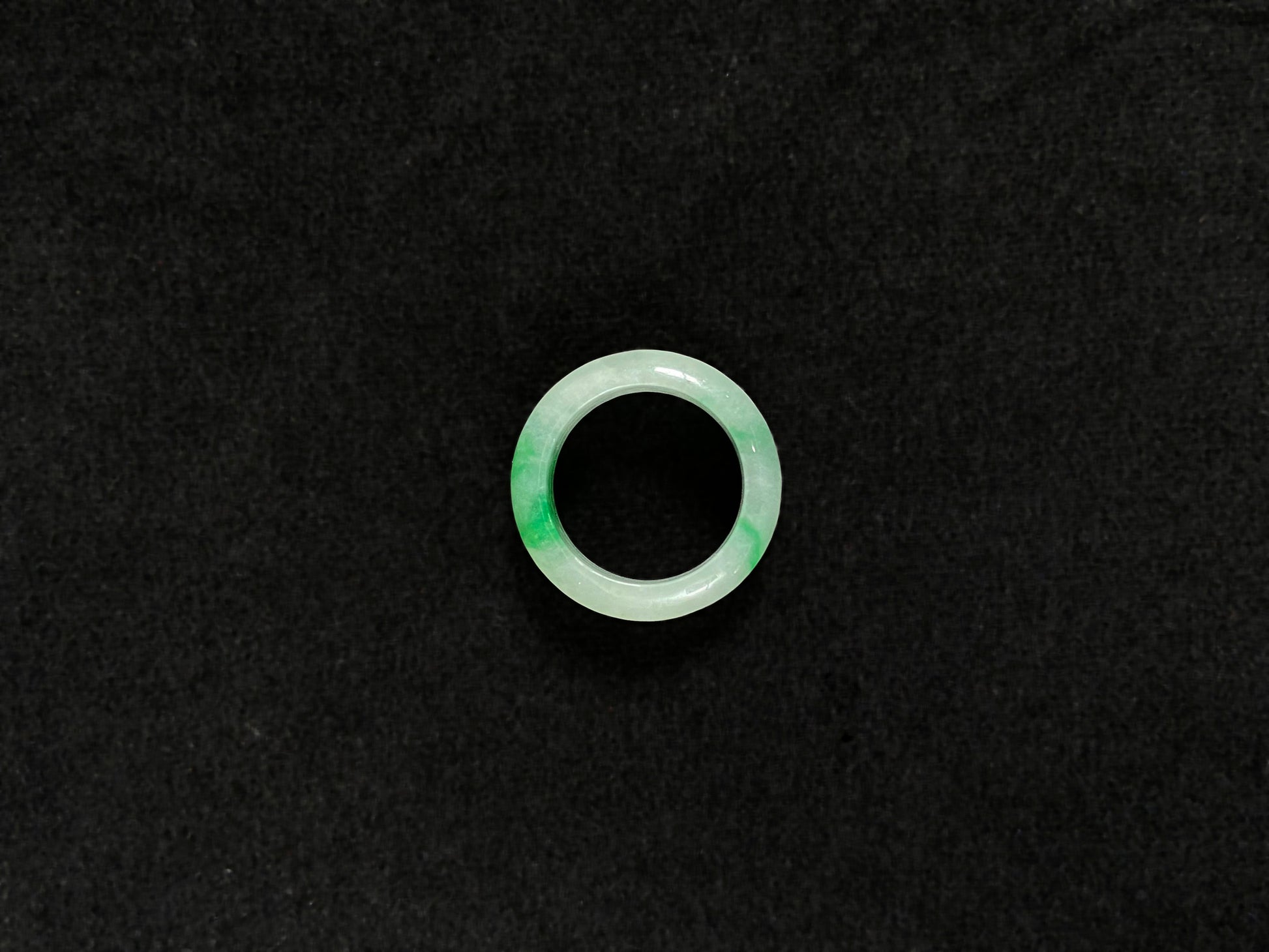 An icy white jadeite ring with natural green accents.