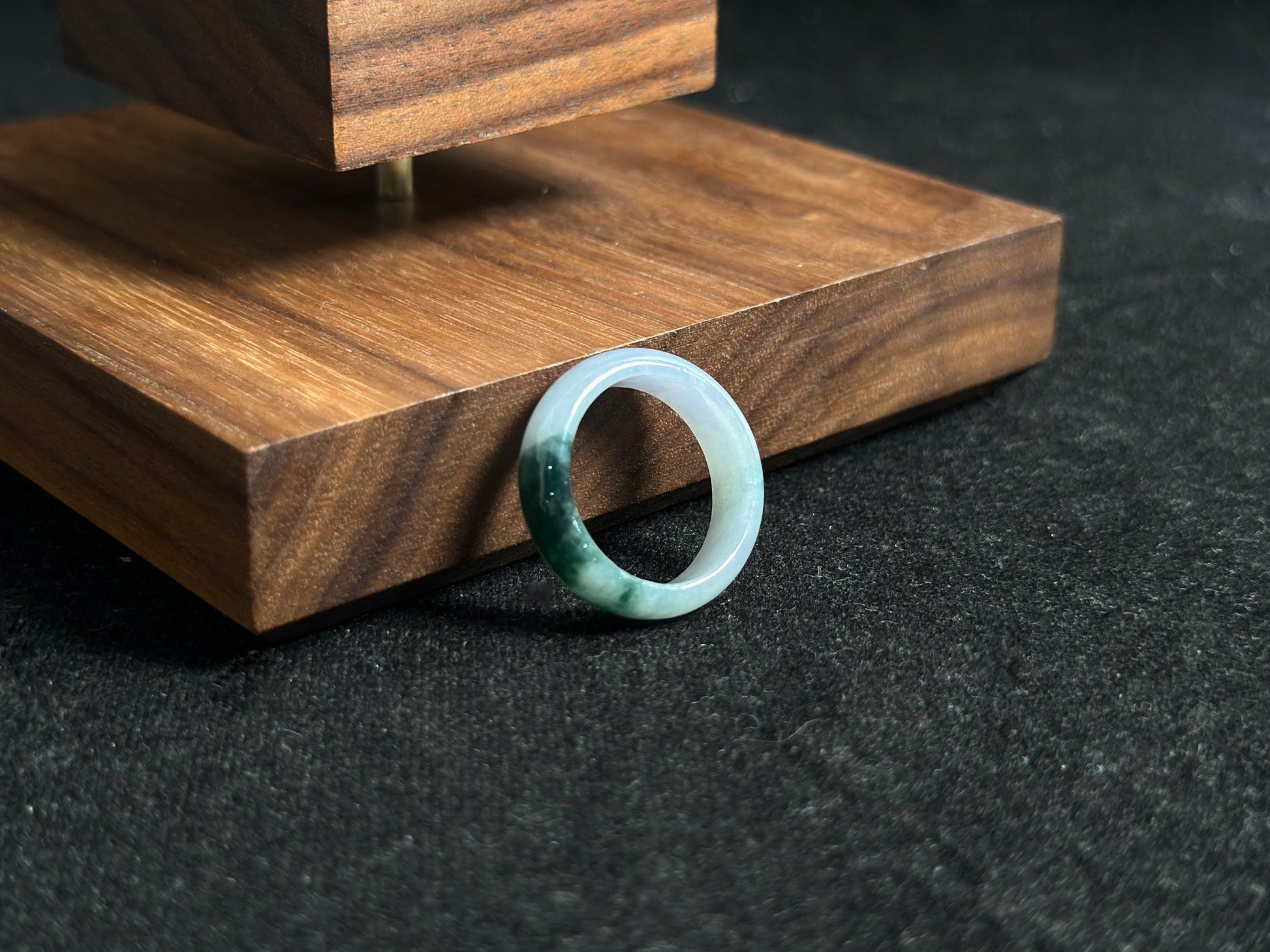 A milky white jadeite ring featuring a single stroke of deep green.
