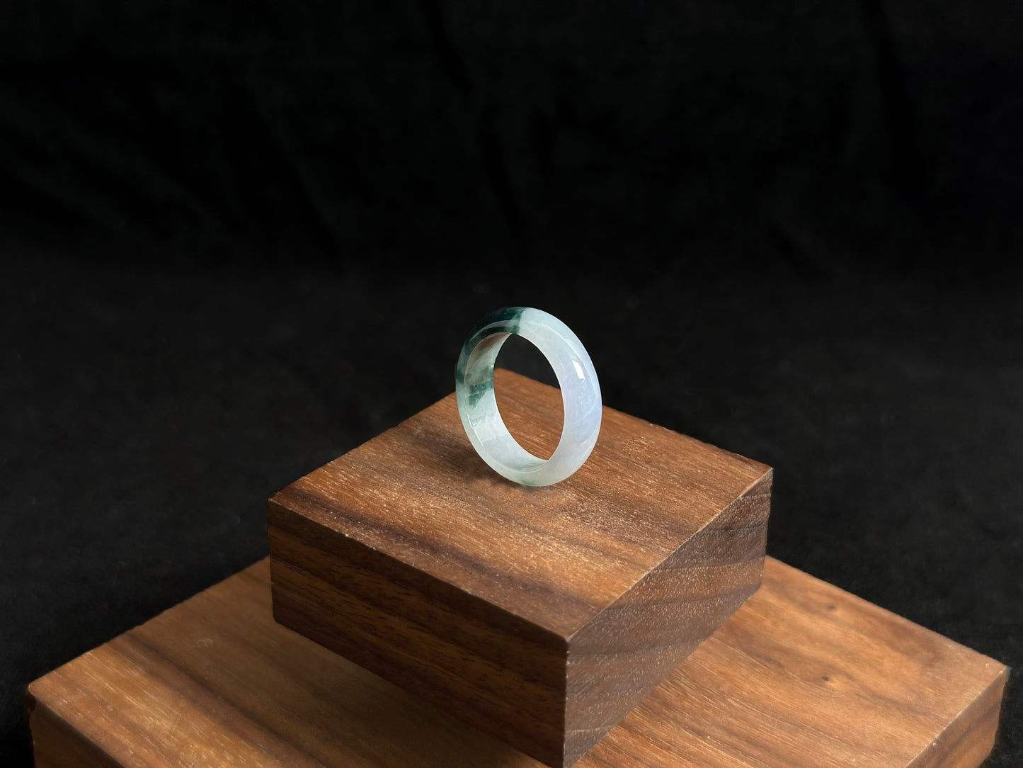 A milky white jadeite ring featuring a single stroke of deep green.