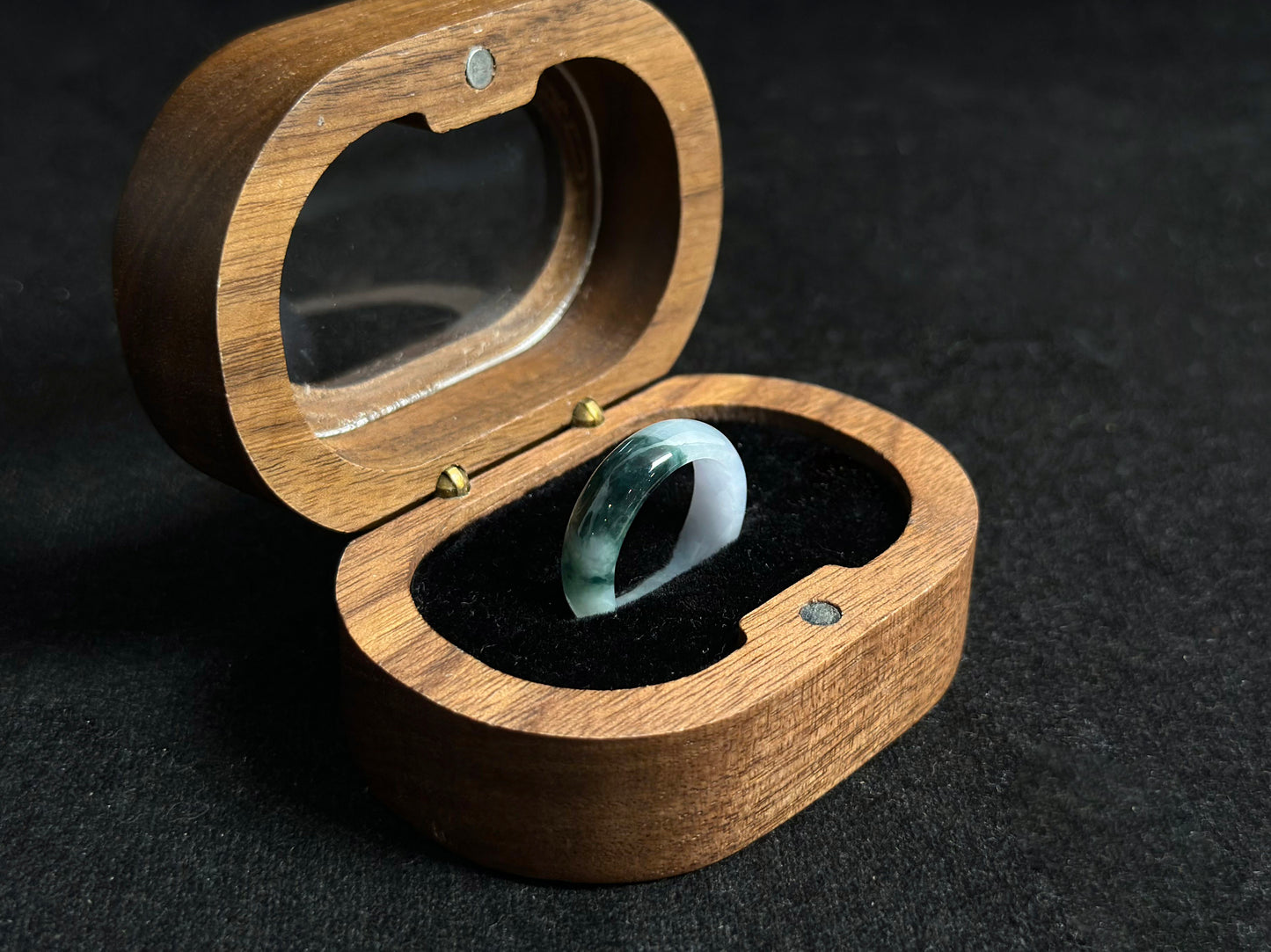 A milky white jadeite ring featuring a single stroke of deep green.