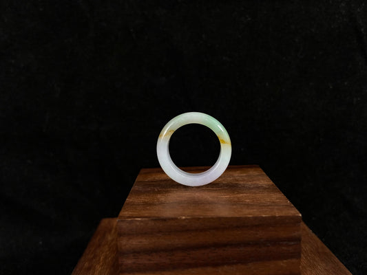 Jade ring on a wooden stand with a dark background