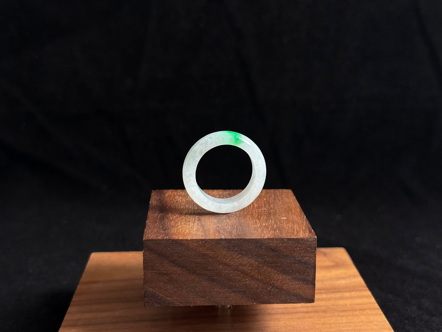 An ice colored jadeite ring adorned with a delicate green accent.