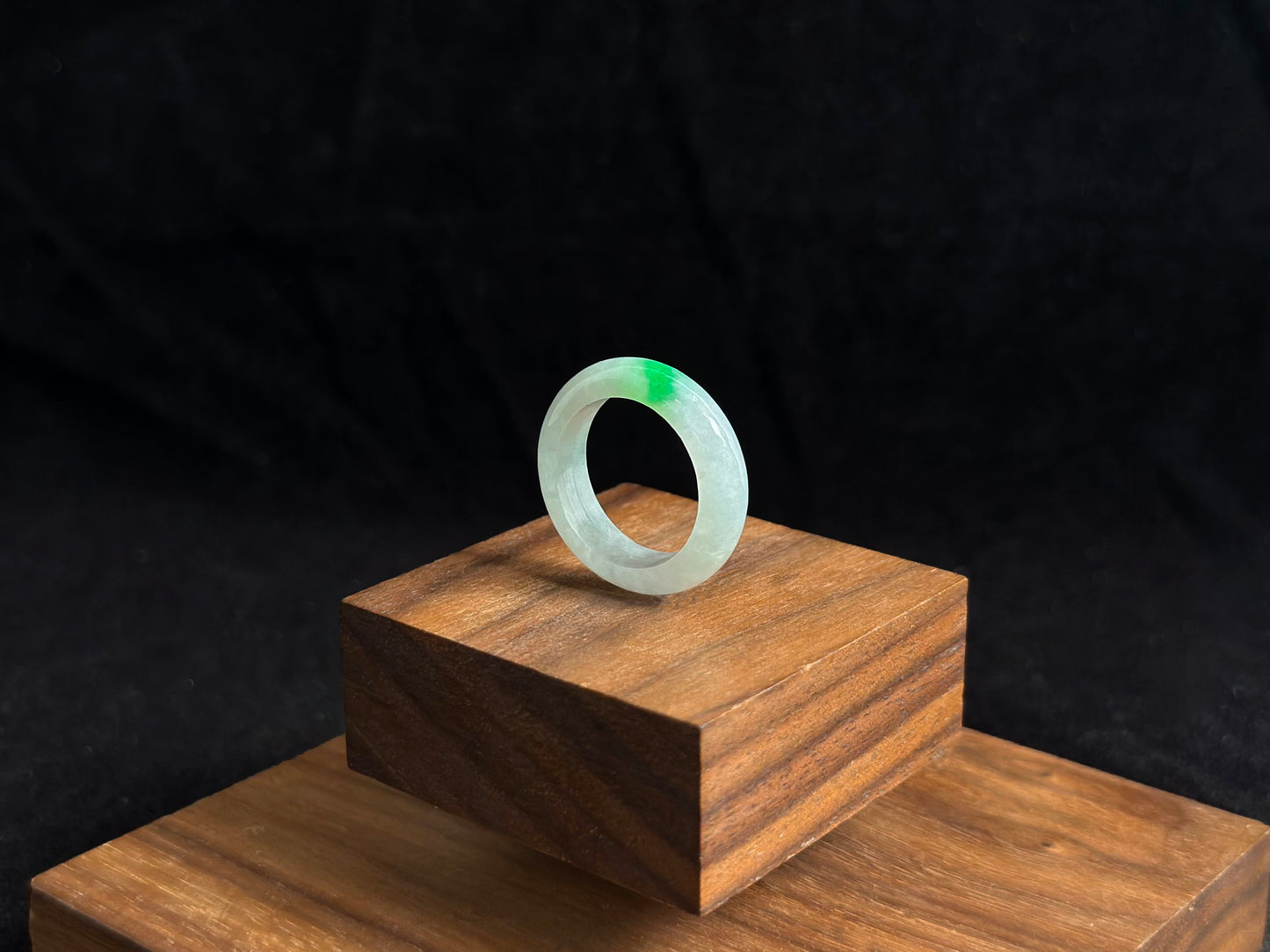 An ice colored jadeite ring adorned with a delicate green accent.