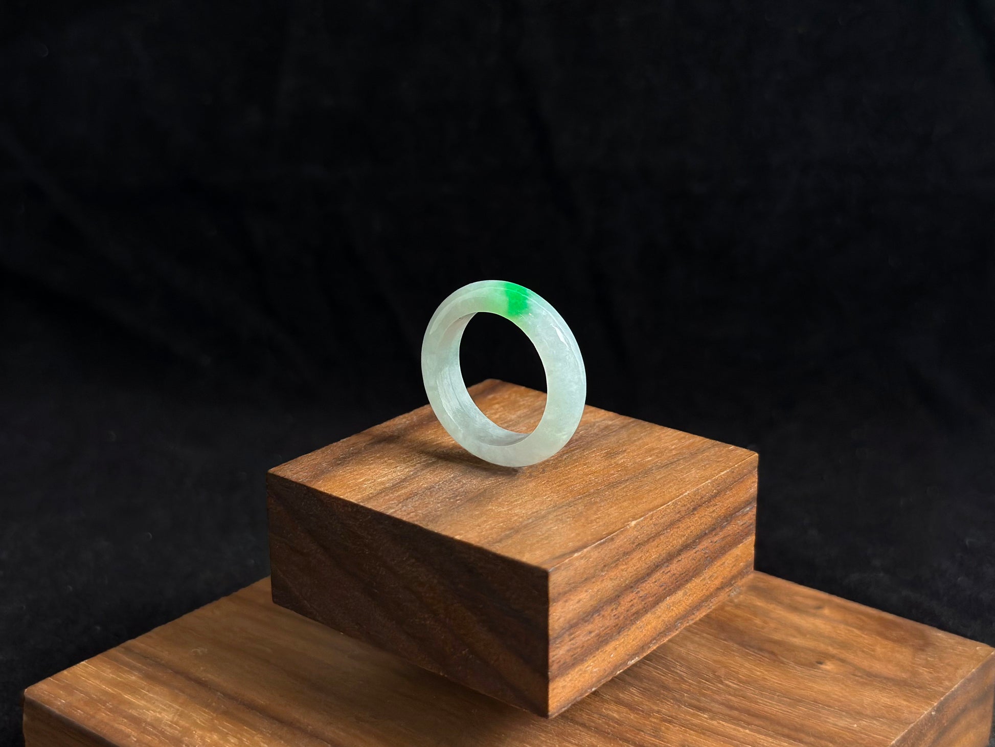 An ice colored jadeite ring adorned with a delicate green accent.