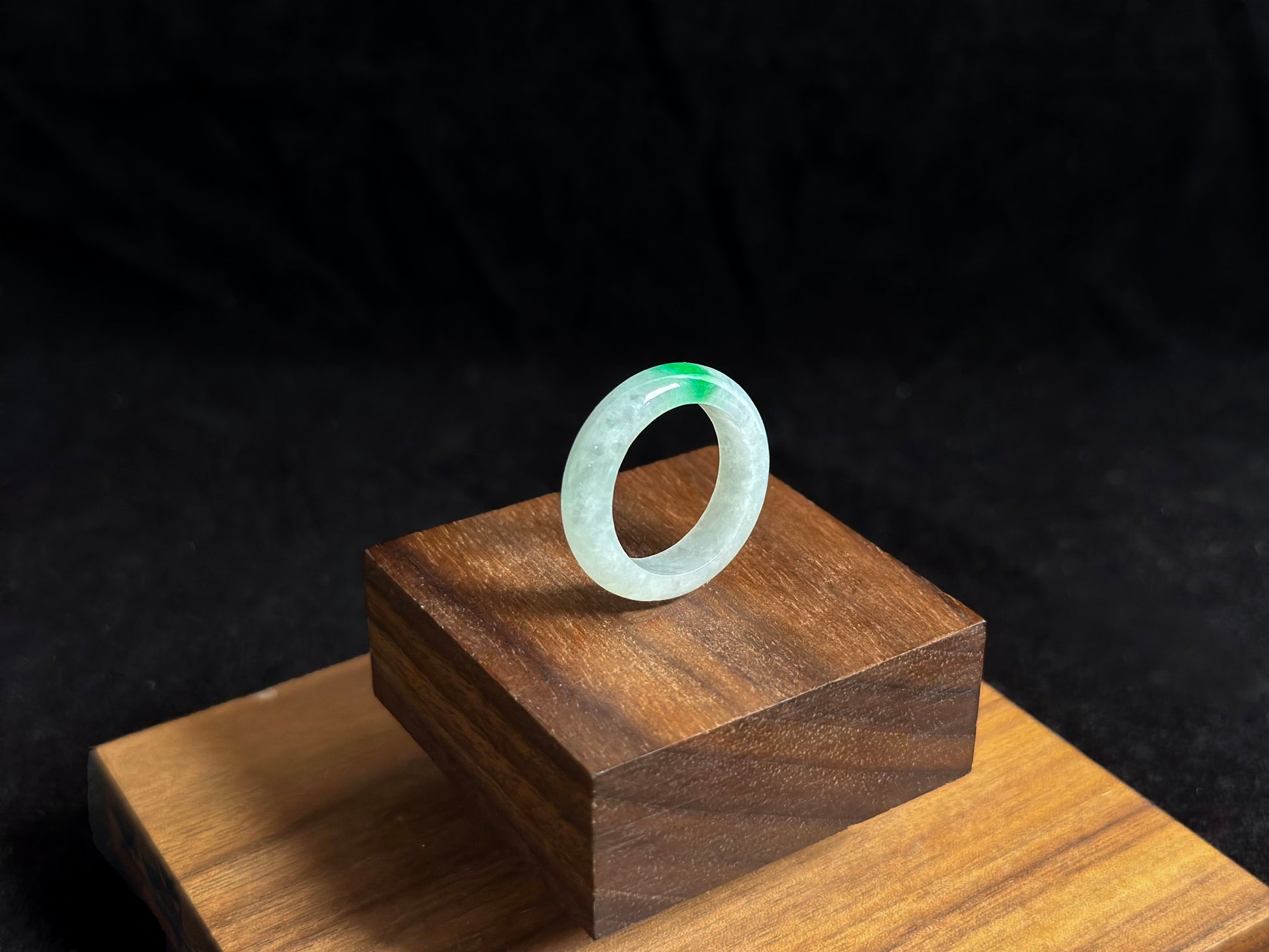 An ice colored jadeite ring adorned with a delicate green accent.