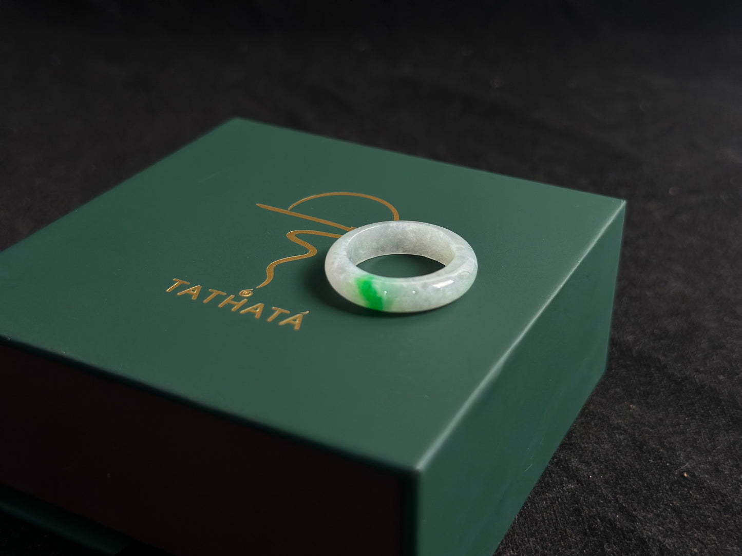An ice colored jadeite ring adorned with a delicate green accent.