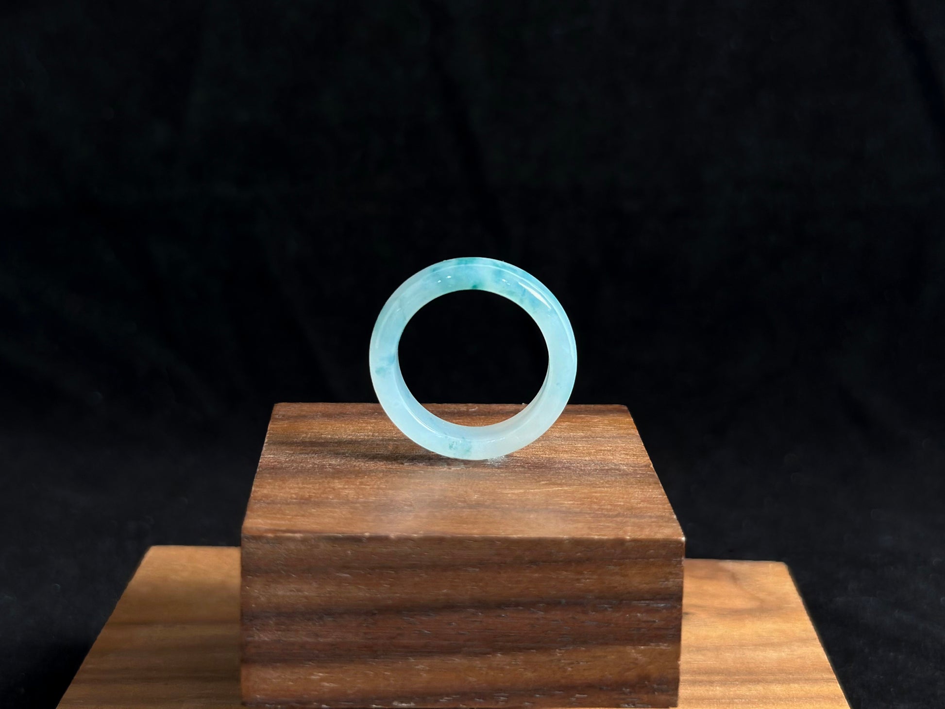 This exquisite jade ring features a transparent base with elegant deep green inclusions floating within the crystal clear stone.