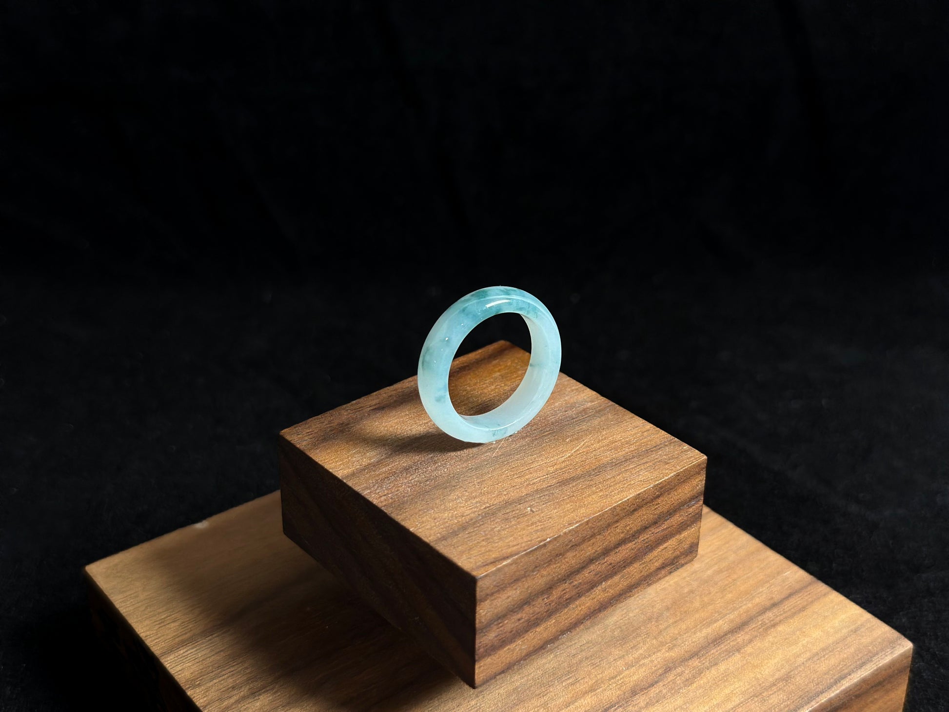 This exquisite jade ring features a transparent base with elegant deep green inclusions floating within the crystal clear stone.