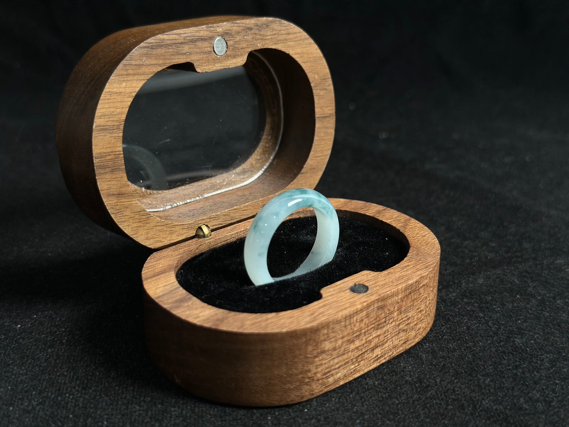 This exquisite jade ring features a transparent base with elegant deep green inclusions floating within the crystal clear stone.