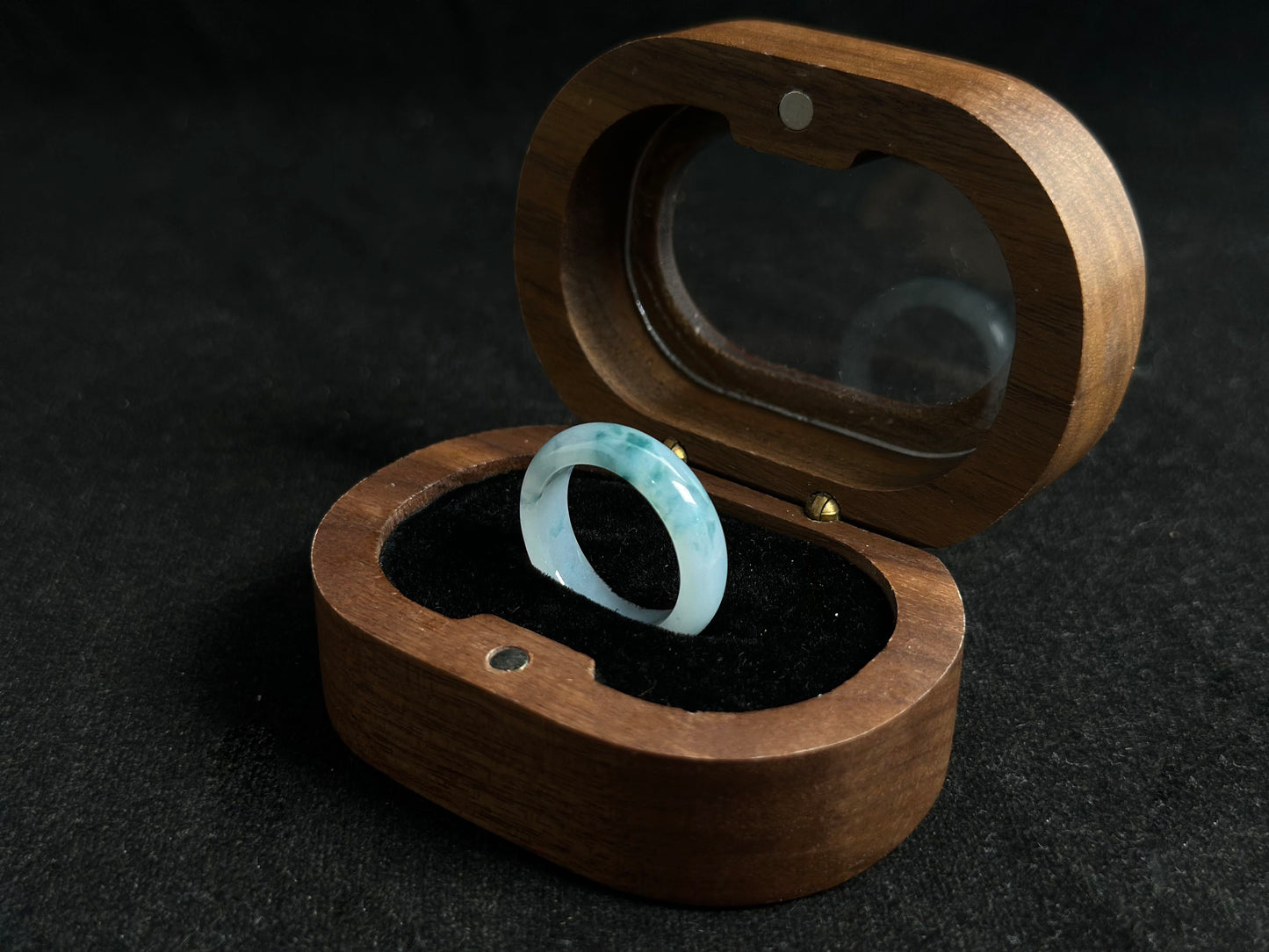 This exquisite jade ring features a transparent base with elegant deep green inclusions floating within the crystal clear stone.