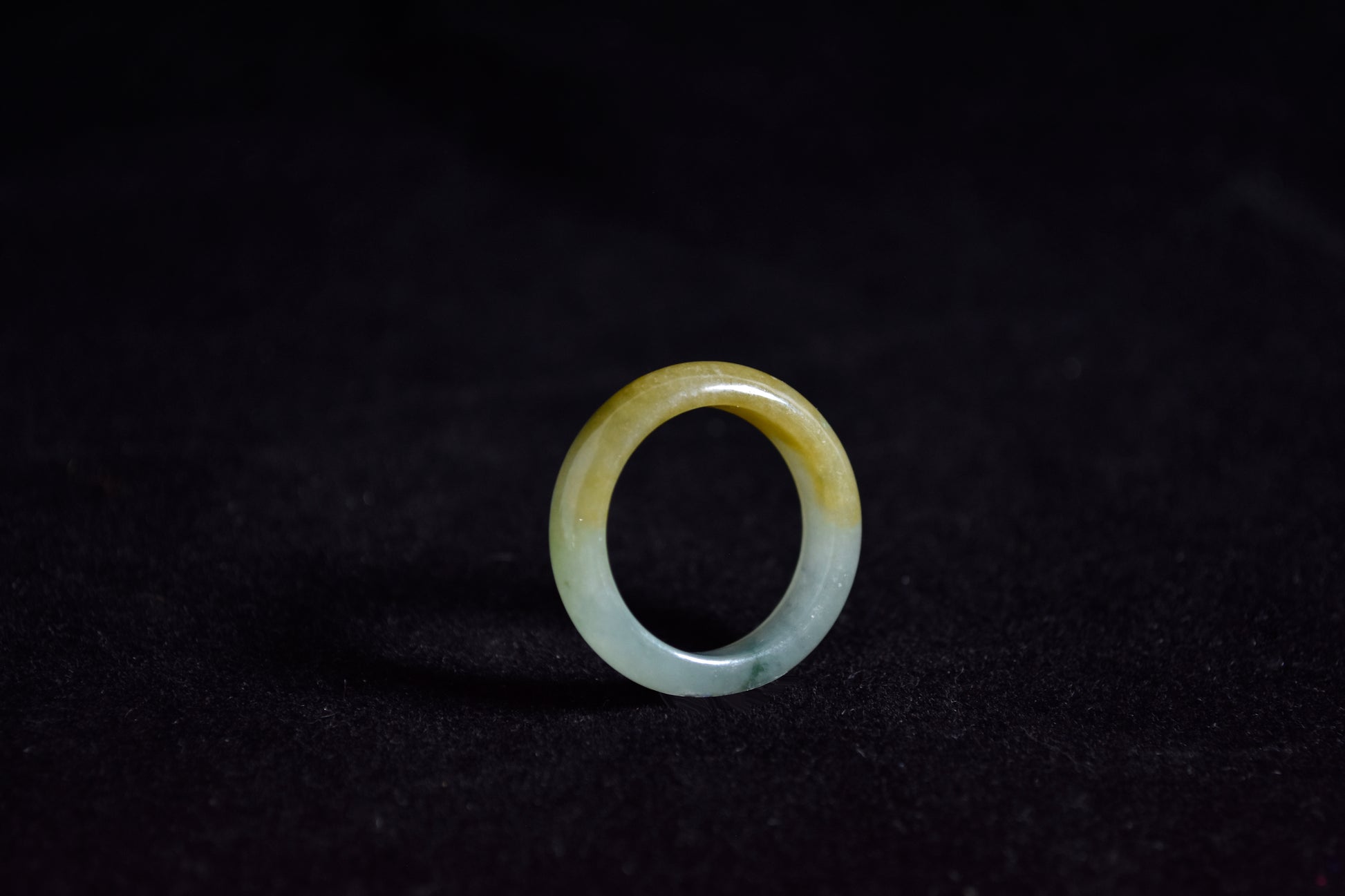 huang fei jade ring on a black background