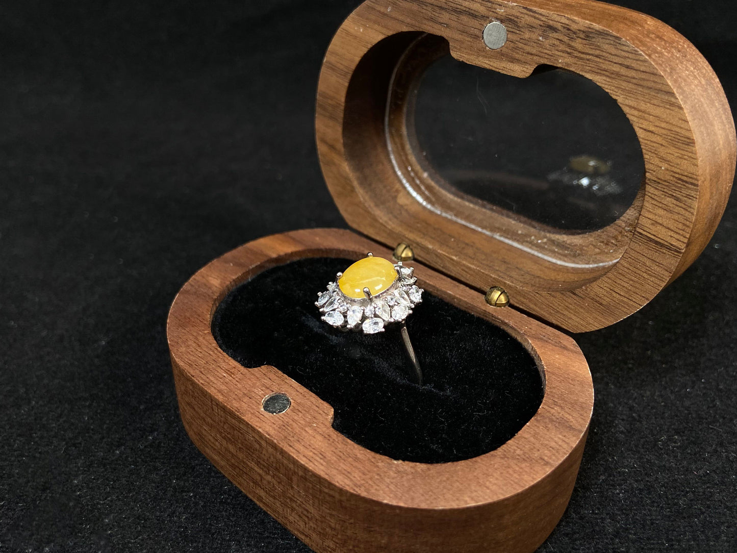 Stunning oval yellow jade is showcased in a diamond paved 925 silver setting.