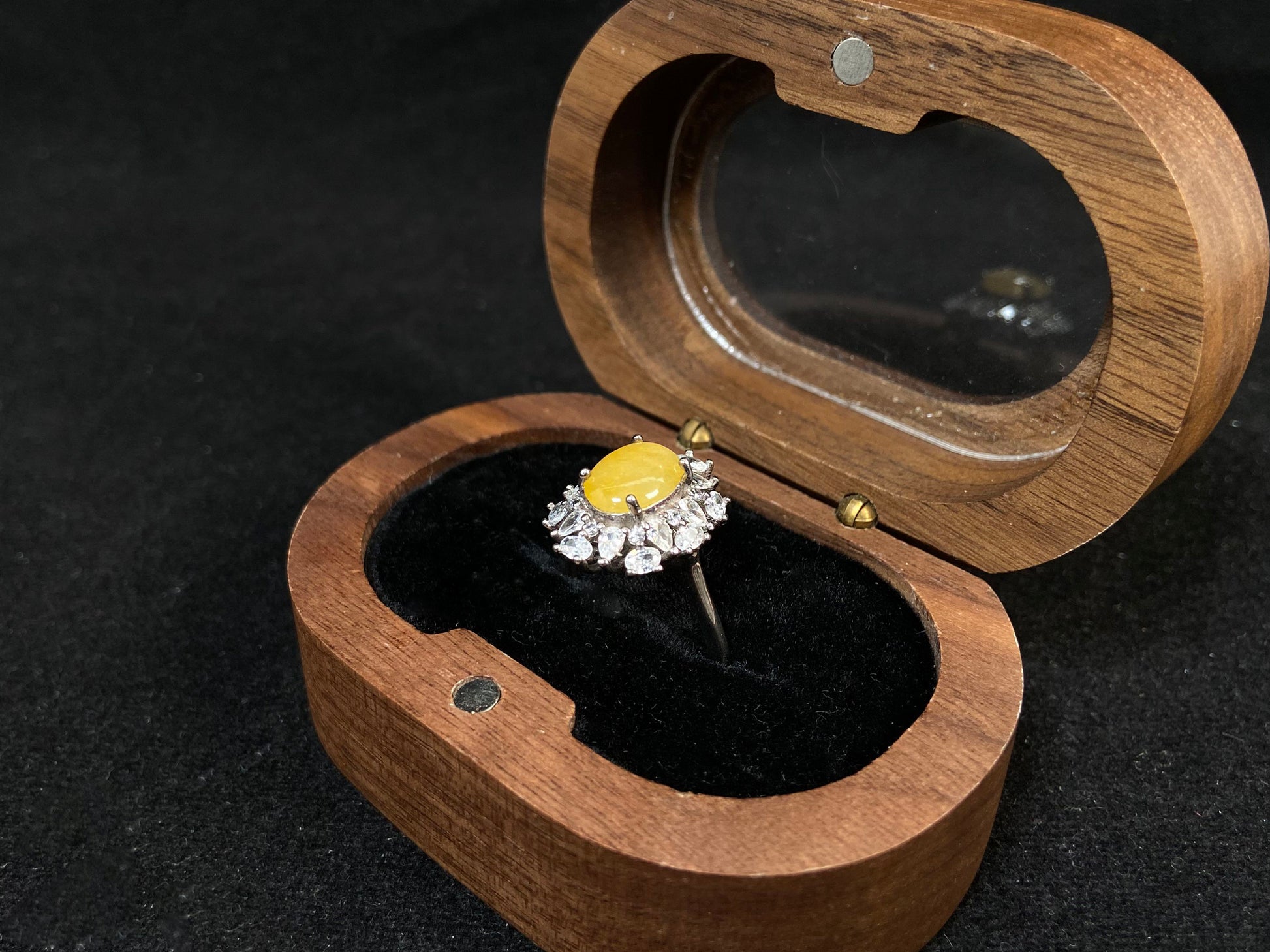 Stunning oval yellow jade is showcased in a diamond paved 925 silver setting.