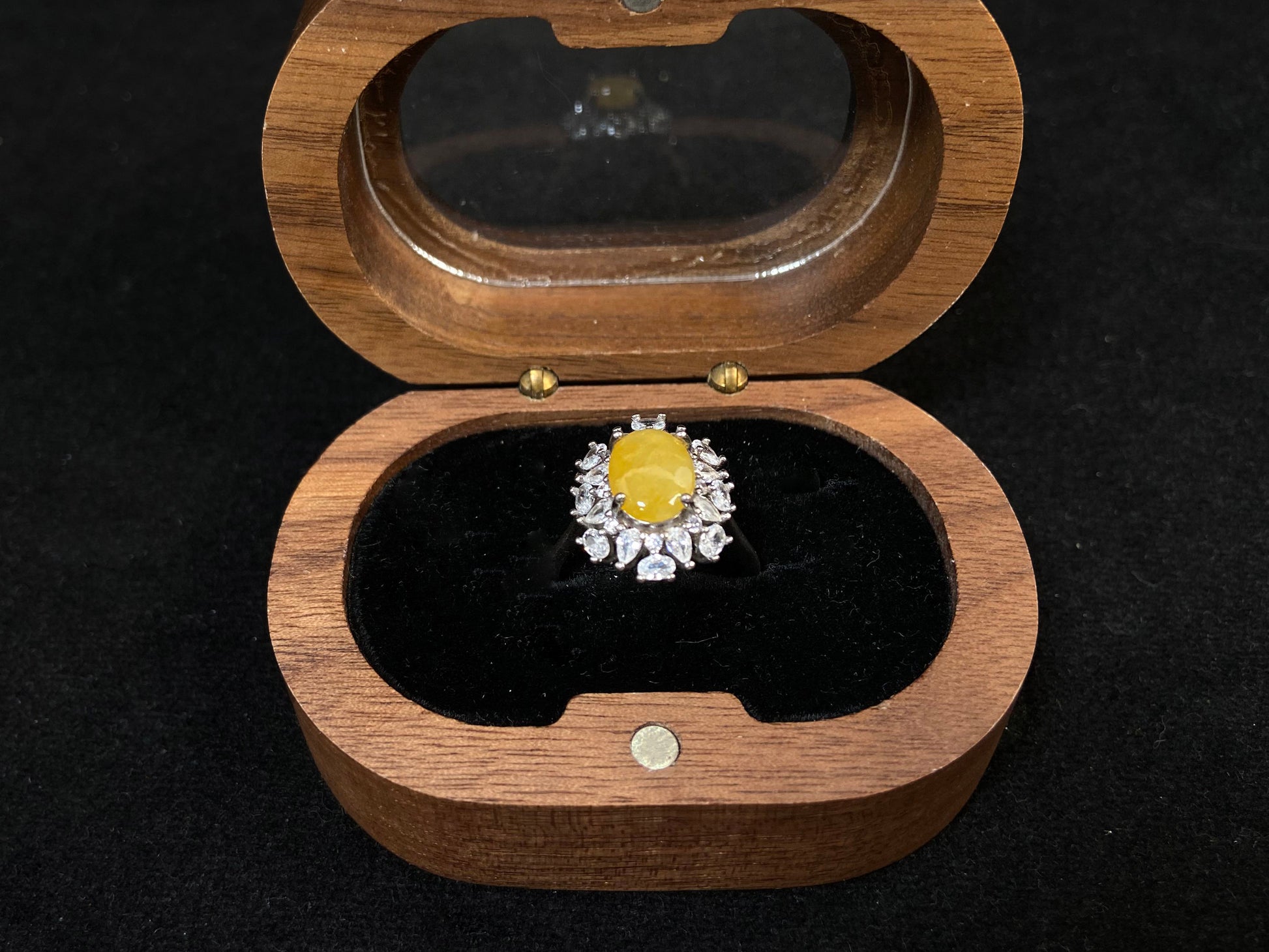 Stunning oval yellow jade is showcased in a diamond paved 925 silver setting.