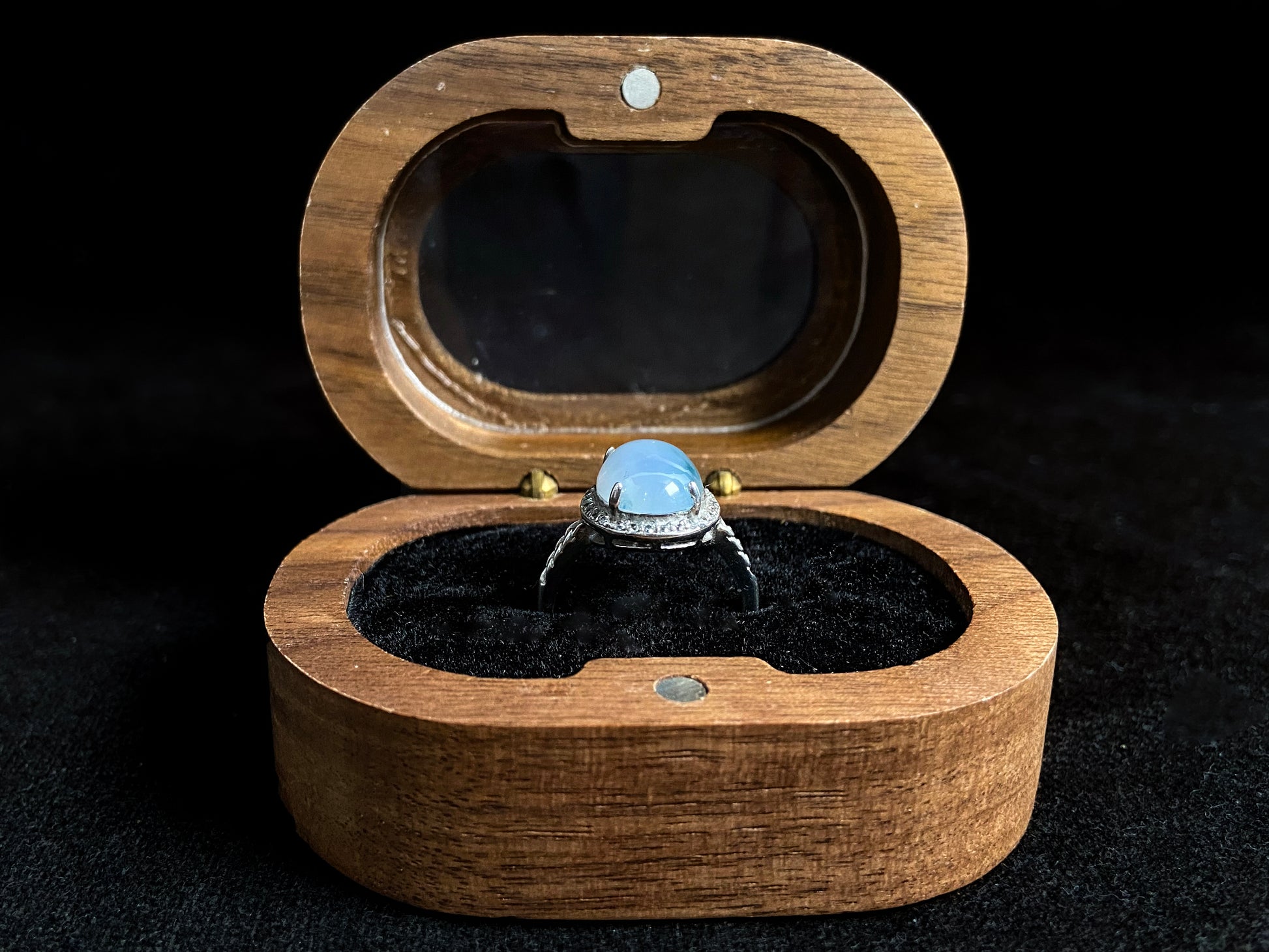 A frosty white jadeite ring featuring a deep green accent on its milky surface, crafted with prong setting to secure the circular gemstone.