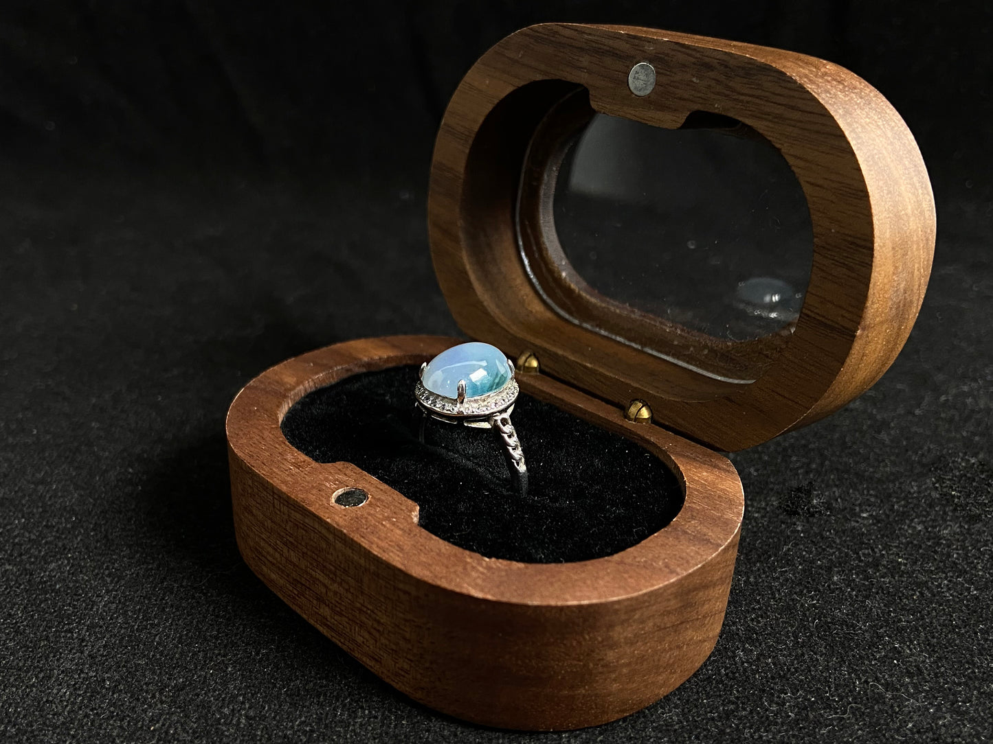 A frosty white jadeite ring featuring a deep green accent on its milky surface, crafted with prong setting to secure the circular gemstone.