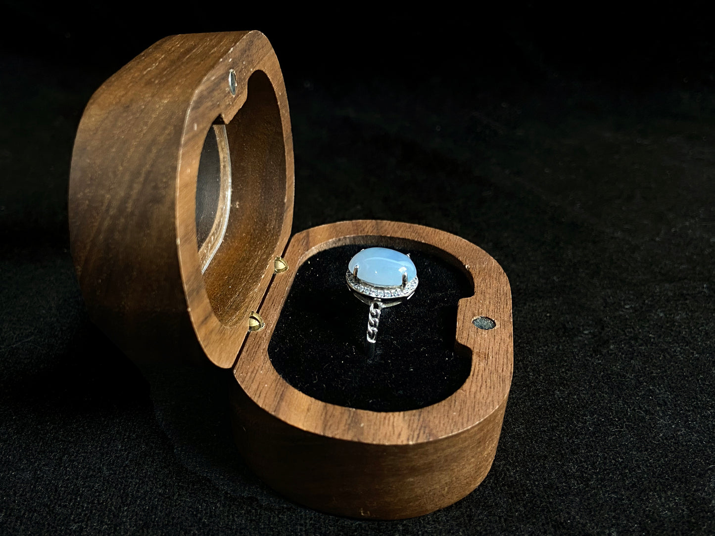 A frosty white jadeite ring featuring a deep green accent on its milky surface, crafted with prong setting to secure the circular gemstone.