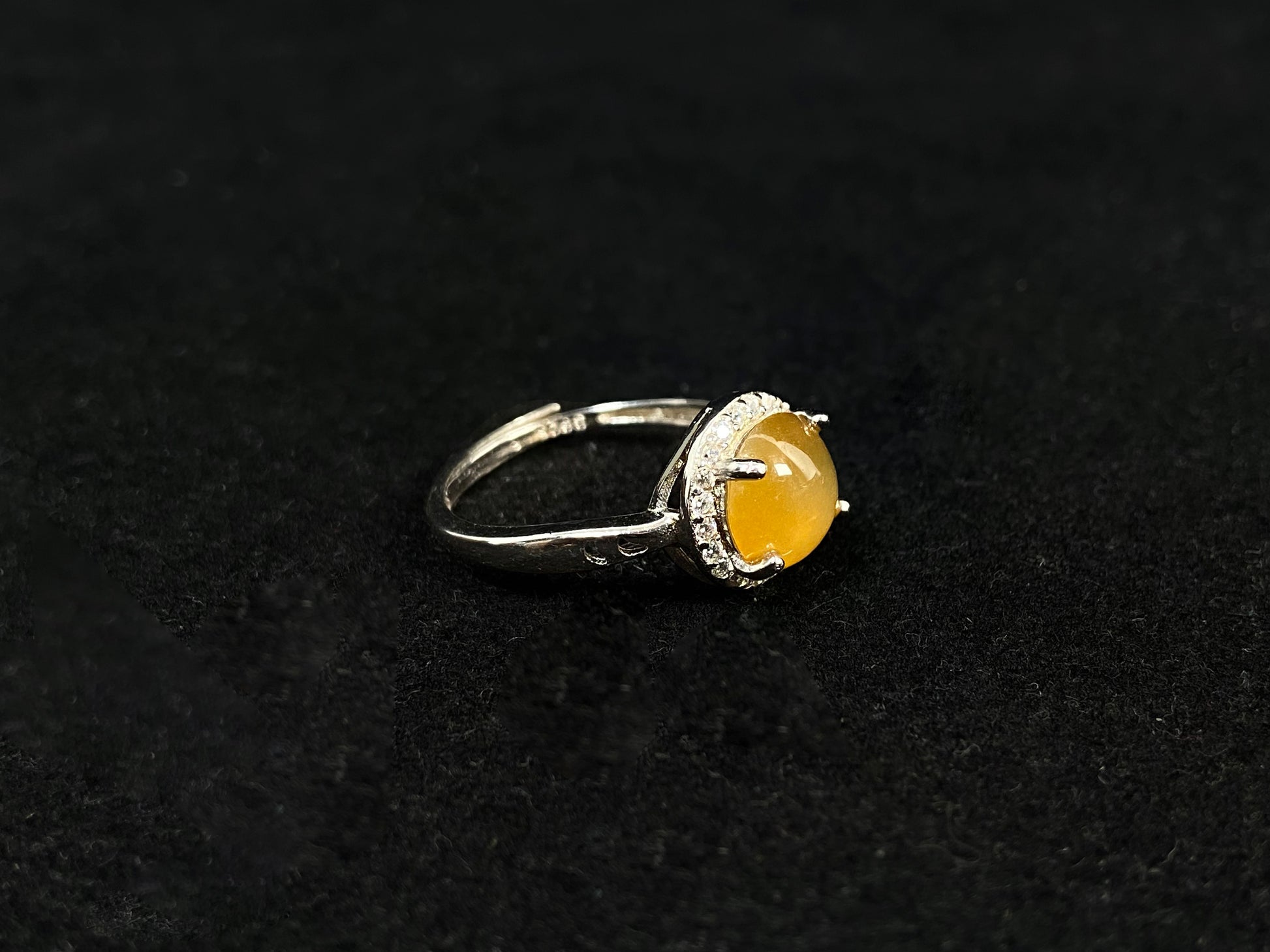 A round brown yellow jade set in 925 silver with prong setting.
