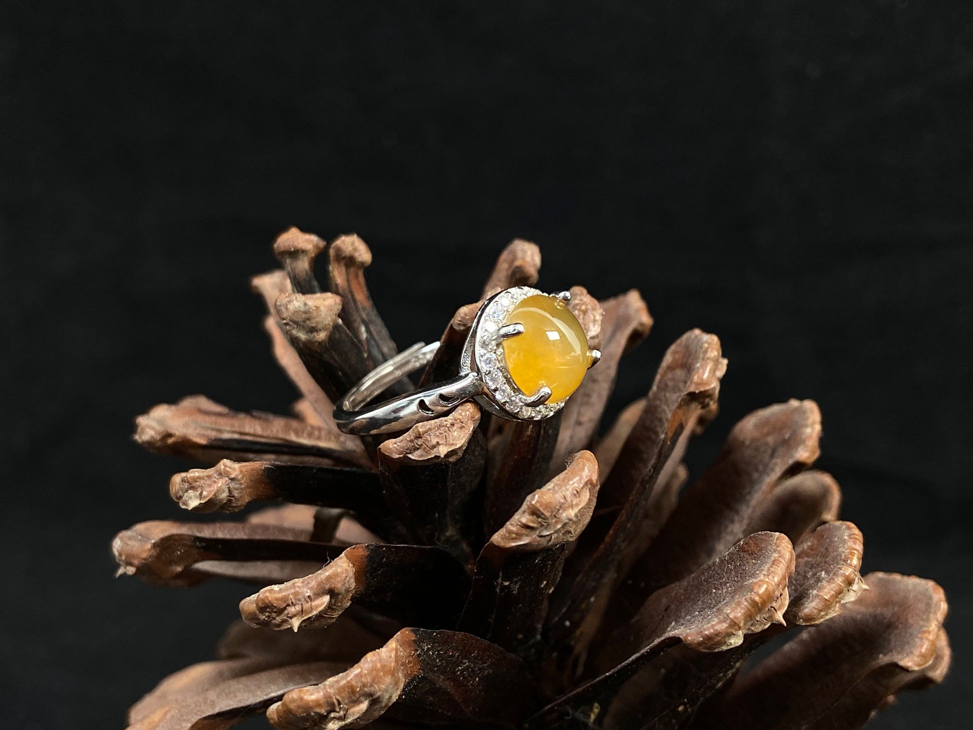 A round brown yellow jade set in 925 silver with prong setting.