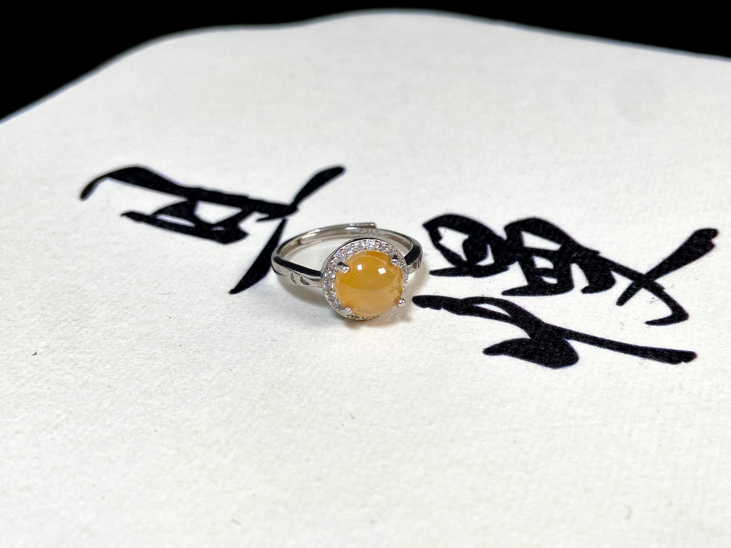 A round brown yellow jade set in 925 silver with prong setting.