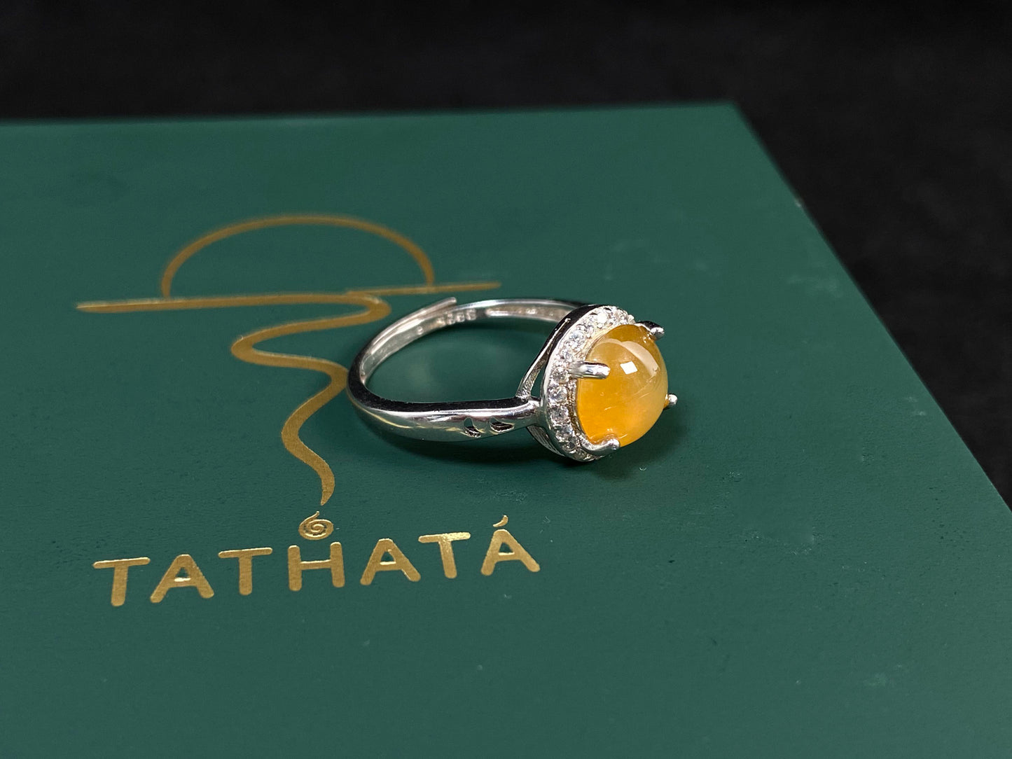 A round brown yellow jade set in 925 silver with prong setting.