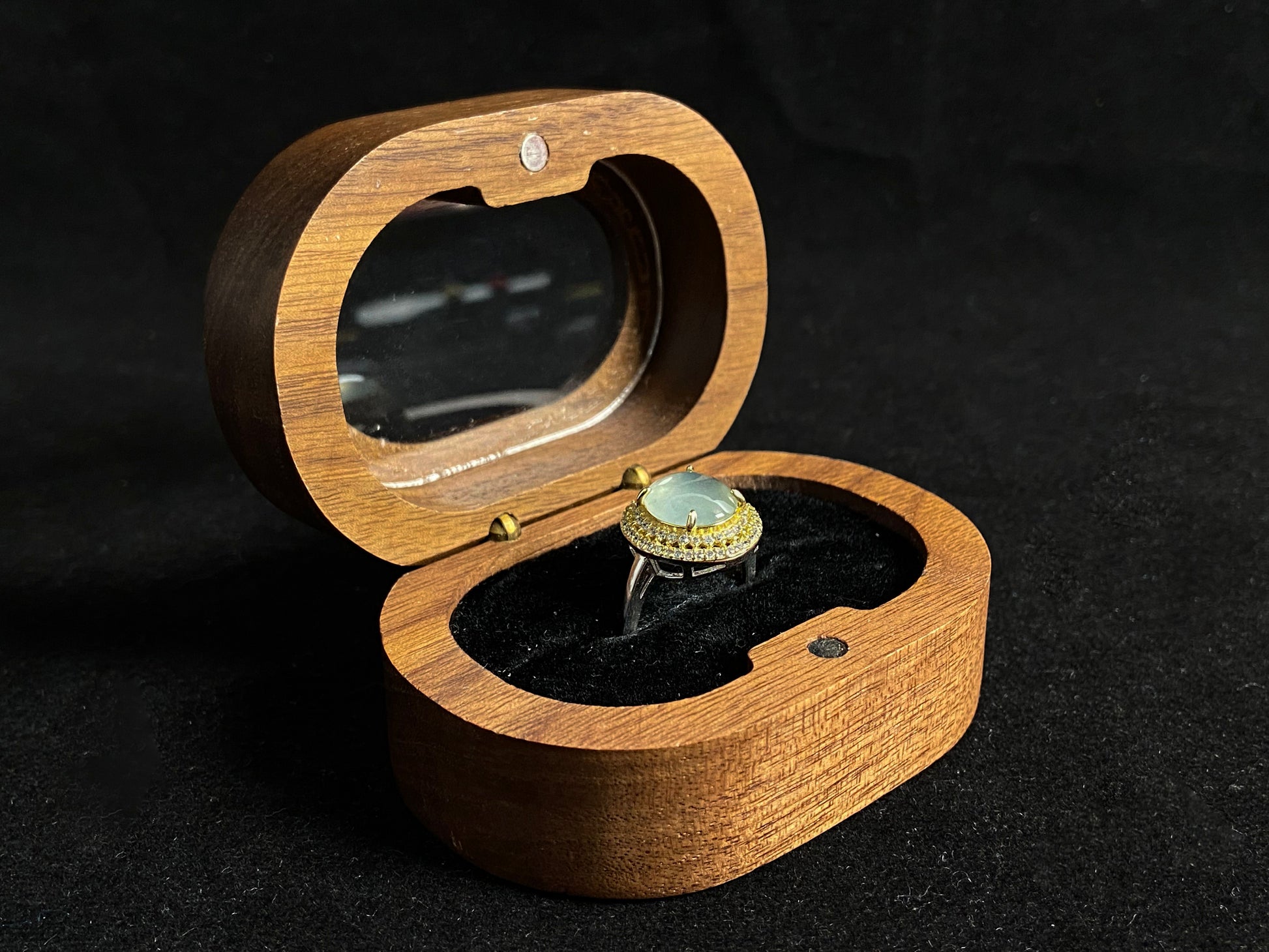 This exquisite ring features a perfectly round, transparent jadeite with exceptional clarity, elegantly secured by channel setting.