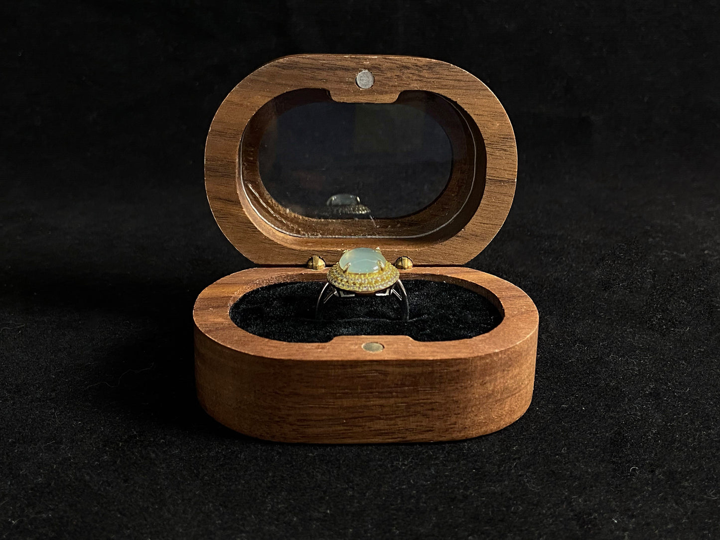 This exquisite ring features a perfectly round, transparent jadeite with exceptional clarity, elegantly secured by channel setting.