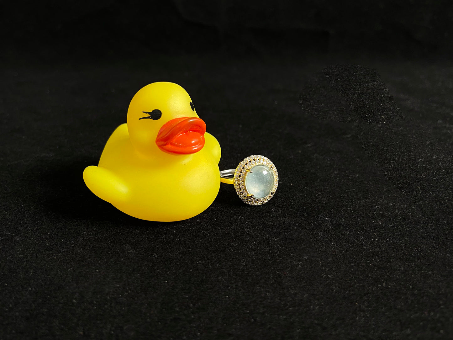 This exquisite ring features a perfectly round, transparent jadeite with exceptional clarity, elegantly secured by channel setting.