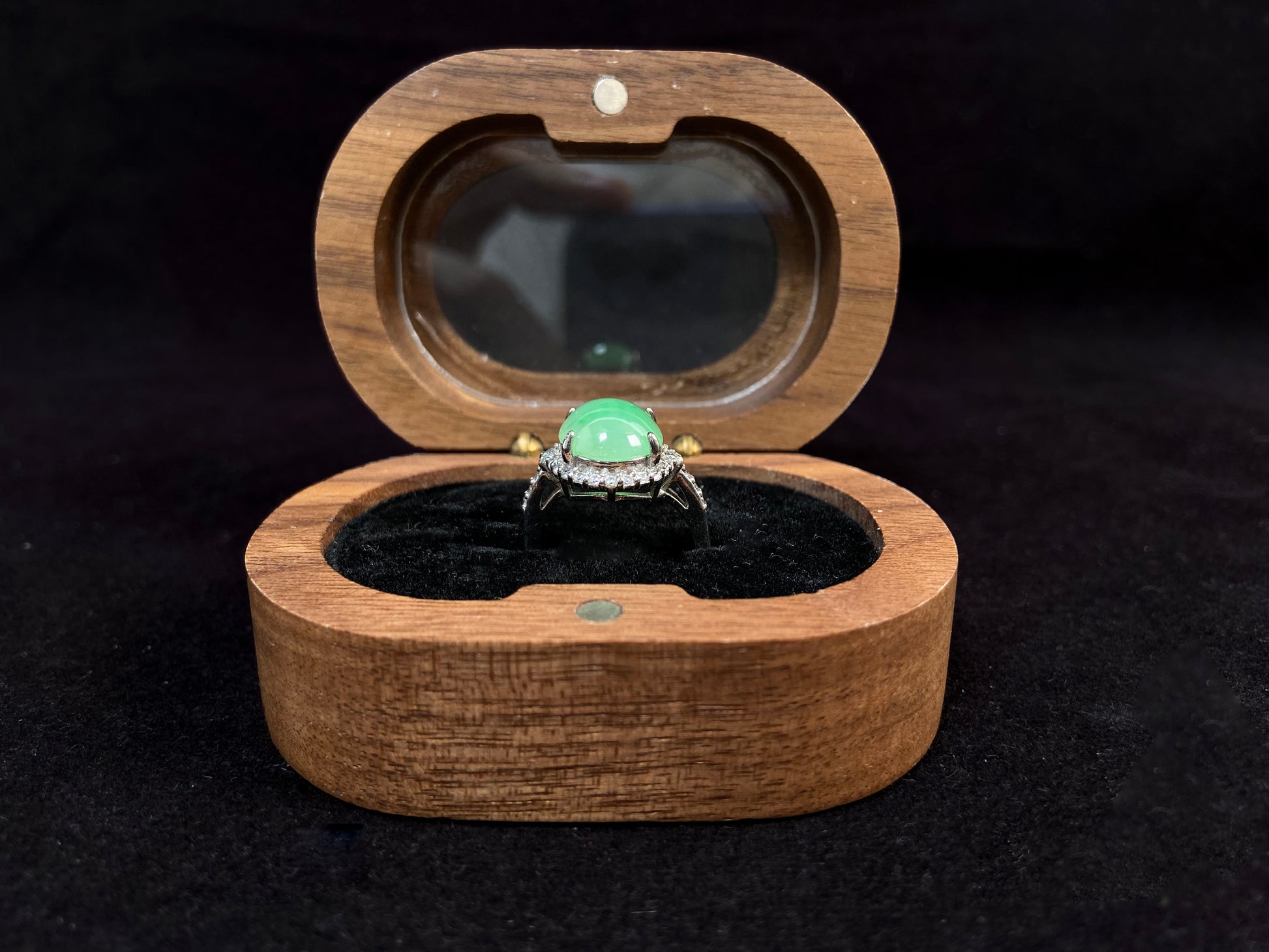 A round apple green jade set in 925 silver with prong setting.