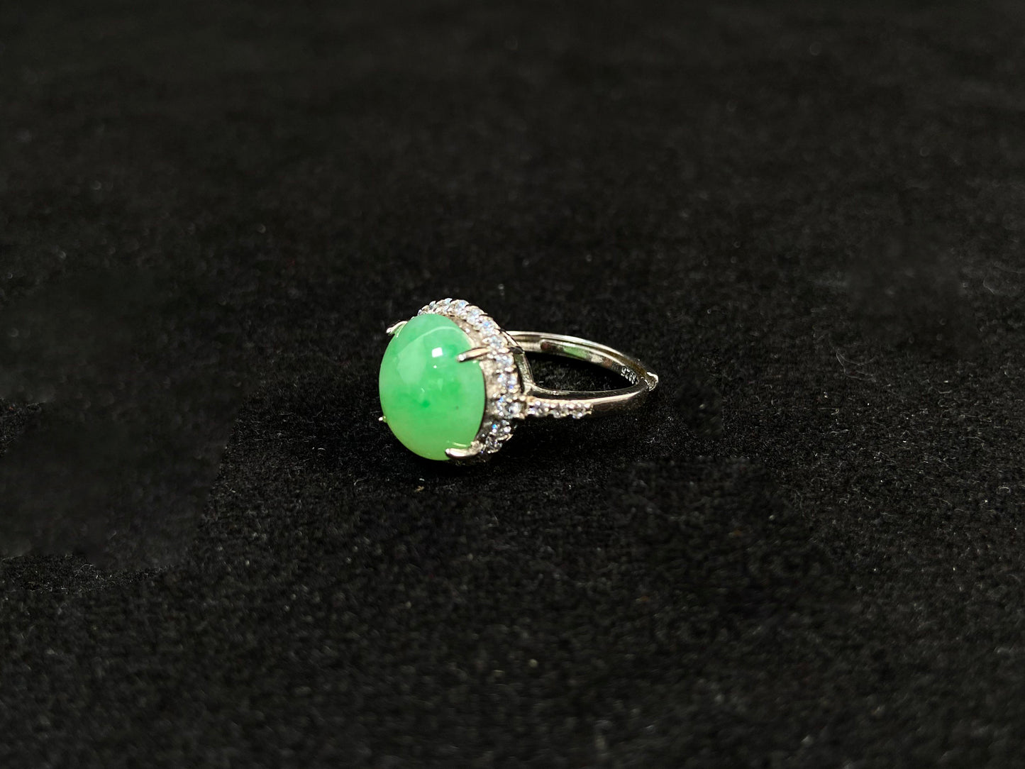A round apple green jade set in 925 silver with prong setting.