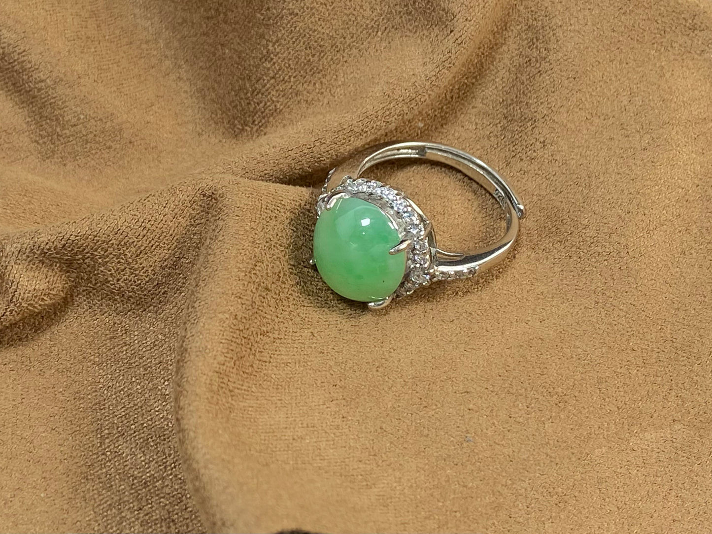 A round apple green jade set in 925 silver with prong setting.