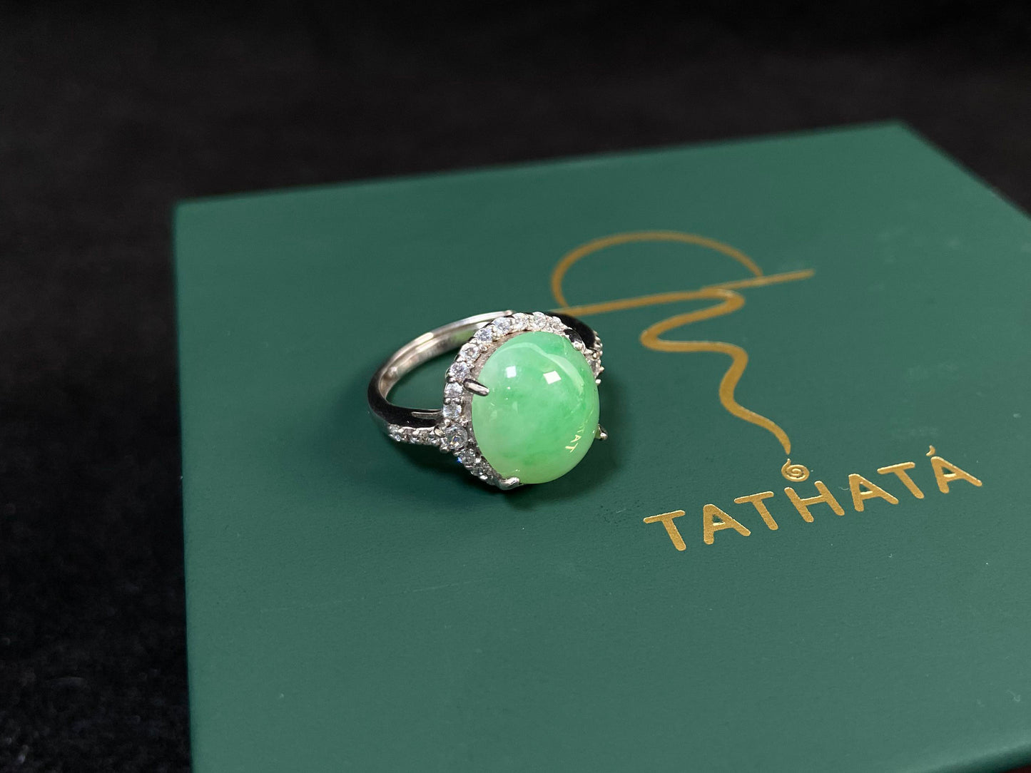 A round apple green jade set in 925 silver with prong setting.