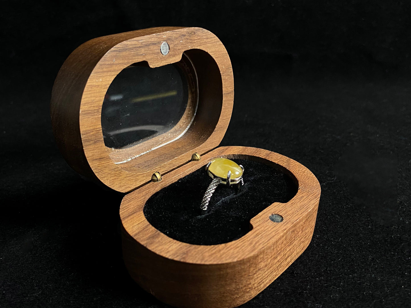 This elegant ring features an oval shaped yellow jadeite, securely set with a channel setting technique.